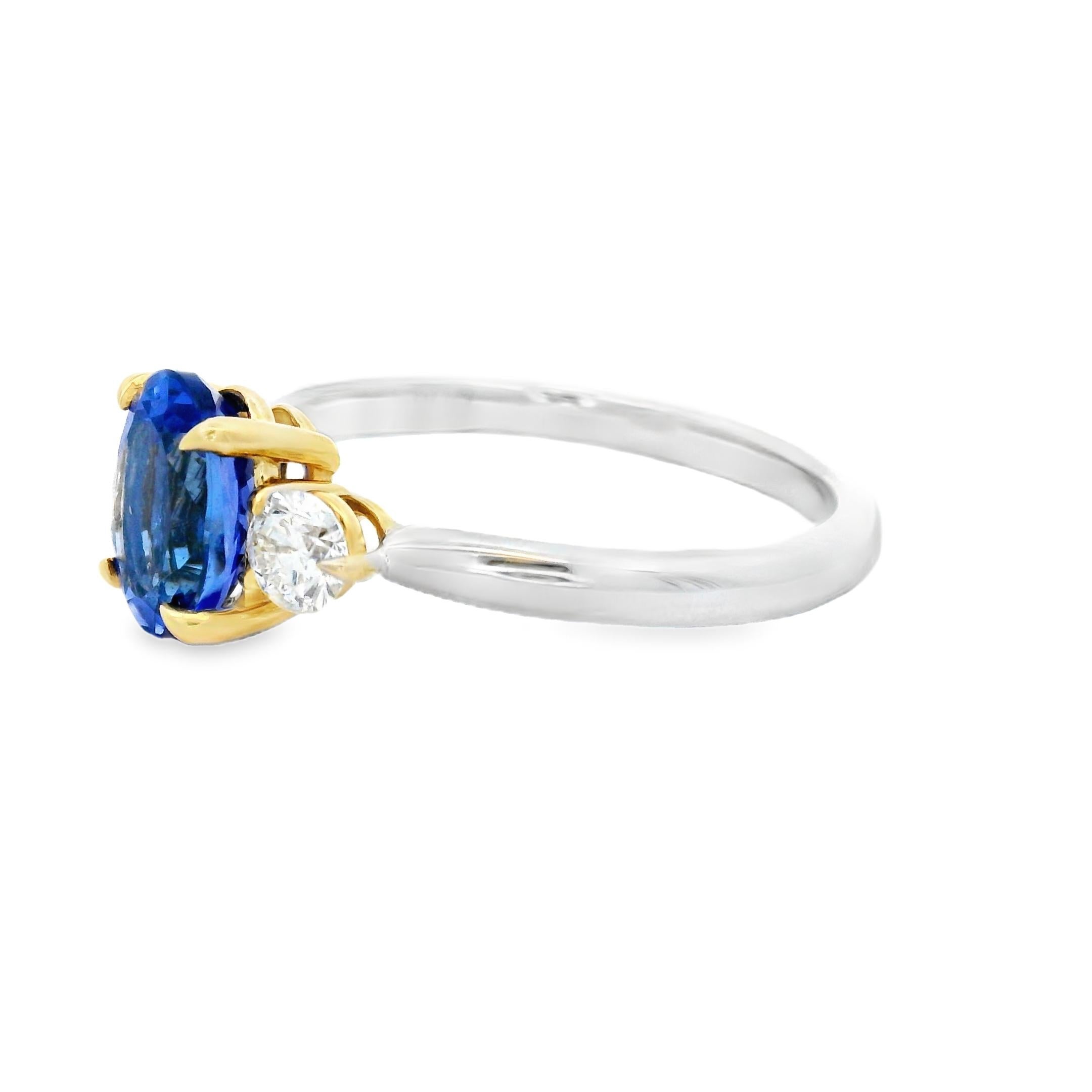 Sleek and vibrant, this three-stone ring features a vivid 1.50-carat oval tanzanite flanked by round diamonds in an elegant two-tone gold setting. The 8x6mm center stone displays the signature violet-blue color tanzanite is prized for, enhanced by