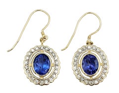 Oval Cut Tanzanite and Diamond Halo Dangle Earrings in 14 Karat Yellow Gold