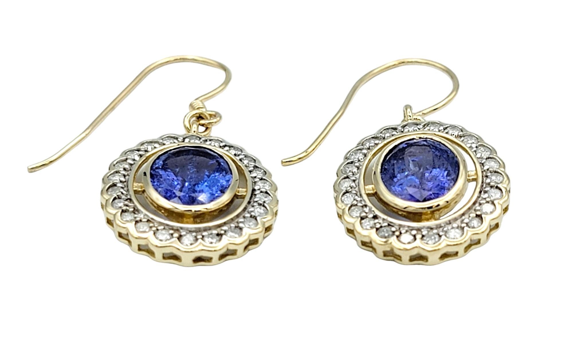 Contemporary Oval Tanzanite and Round Diamond Halo Dangle Earrings in 14 Karat Yellow Gold For Sale
