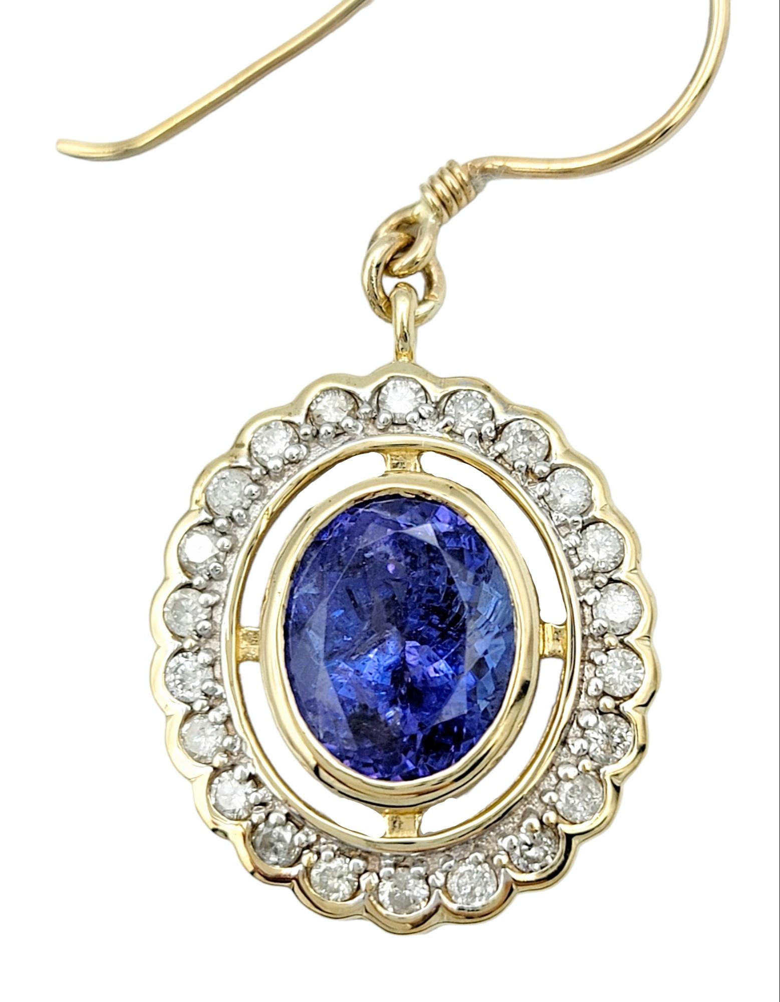 Oval Cut Oval Tanzanite and Round Diamond Halo Dangle Earrings in 14 Karat Yellow Gold For Sale