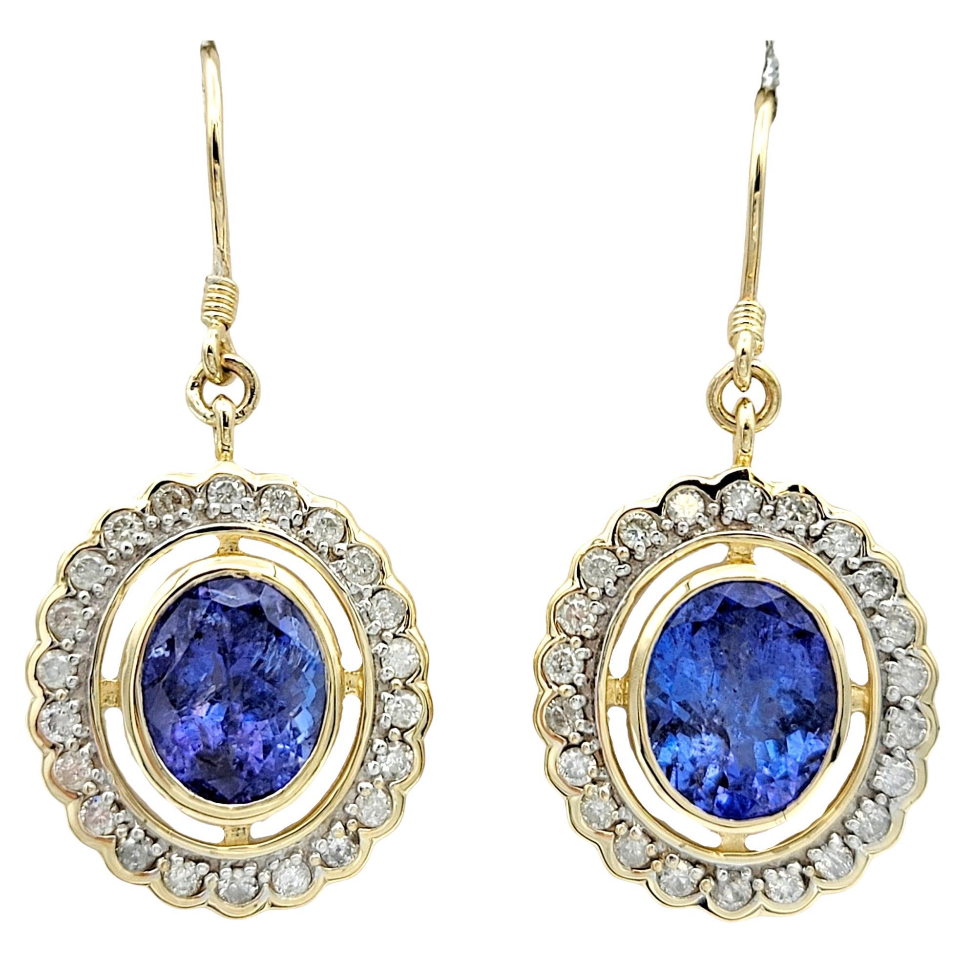 Oval Tanzanite and Round Diamond Halo Dangle Earrings in 14 Karat Yellow Gold For Sale