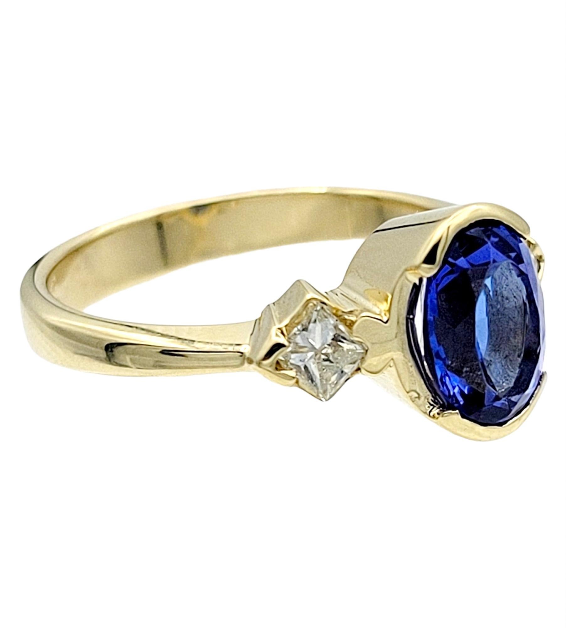 Ring Size: 7 

Featuring an exquisite three-stone tanzanite and diamond ring in polished 14 karat yellow gold. This stunning piece showcases the captivating beauty of tanzanite, renowned for its mesmerizing violet-blue hue, surrounded on either side