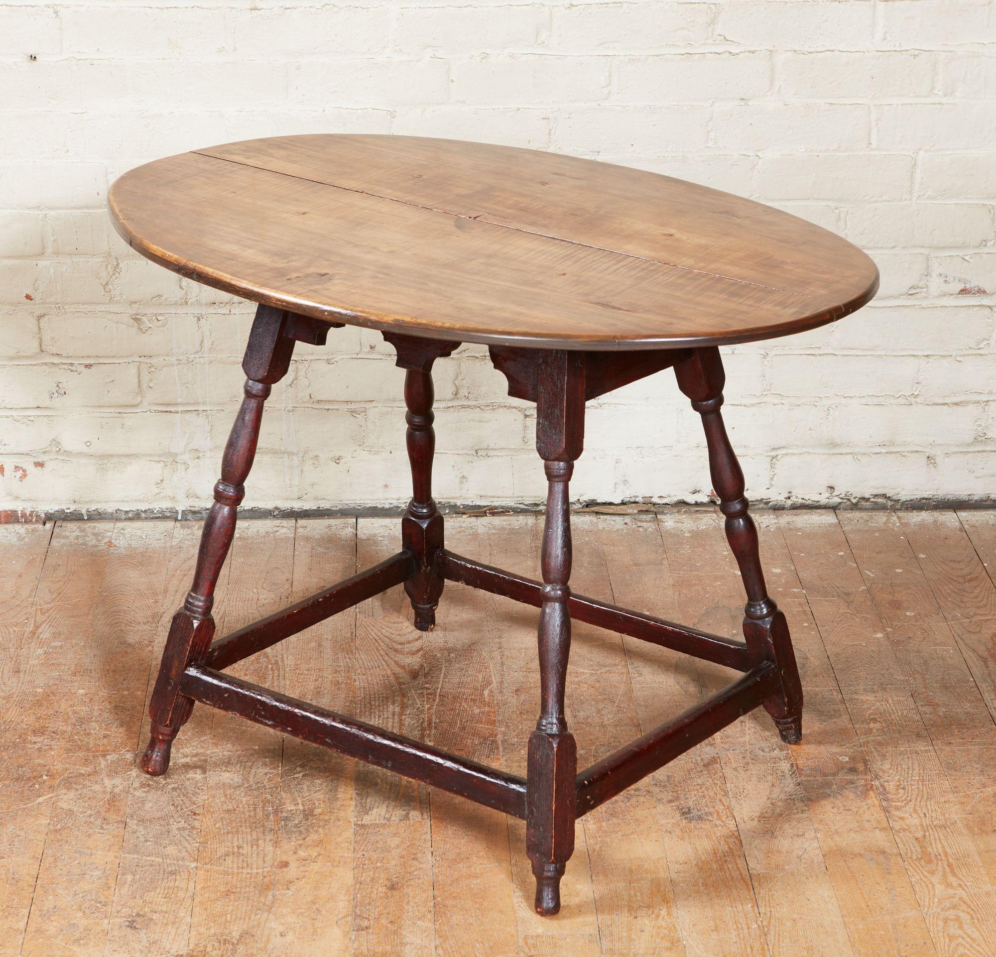 Quirky oval stretcher base table having tiger maple oval top over dramatically splayed base with boldly scalloped side stretchers, crisply turned legs joined by box stretchers.