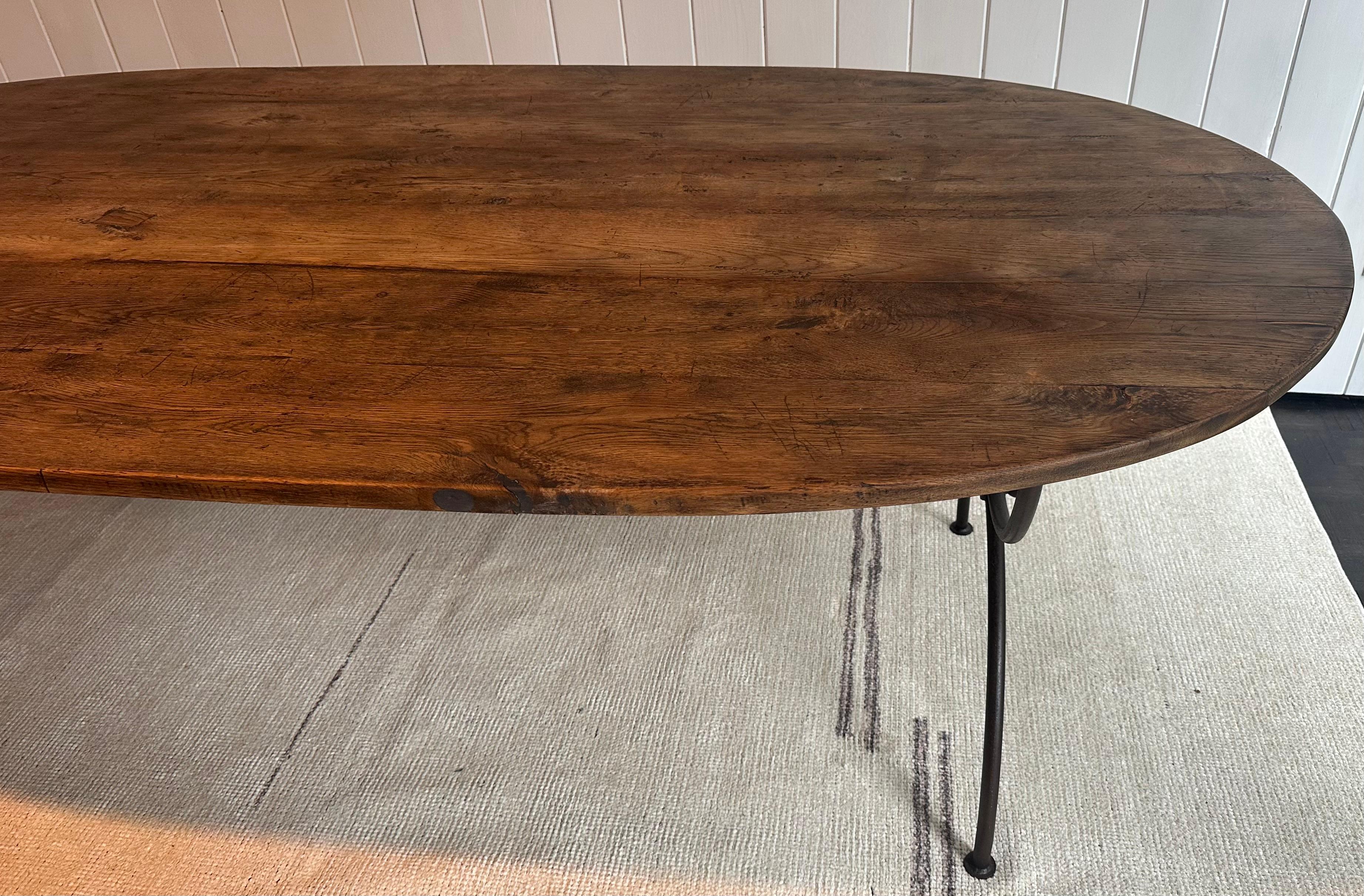 Rustic oval teak table top with wonderful aged patina on a stylish custom iron base made by us, will make a perfect dining room, kitchen or that outdoor garden patio table.
The curule form iron metal table base taken from the Greco-Roman time, gives
