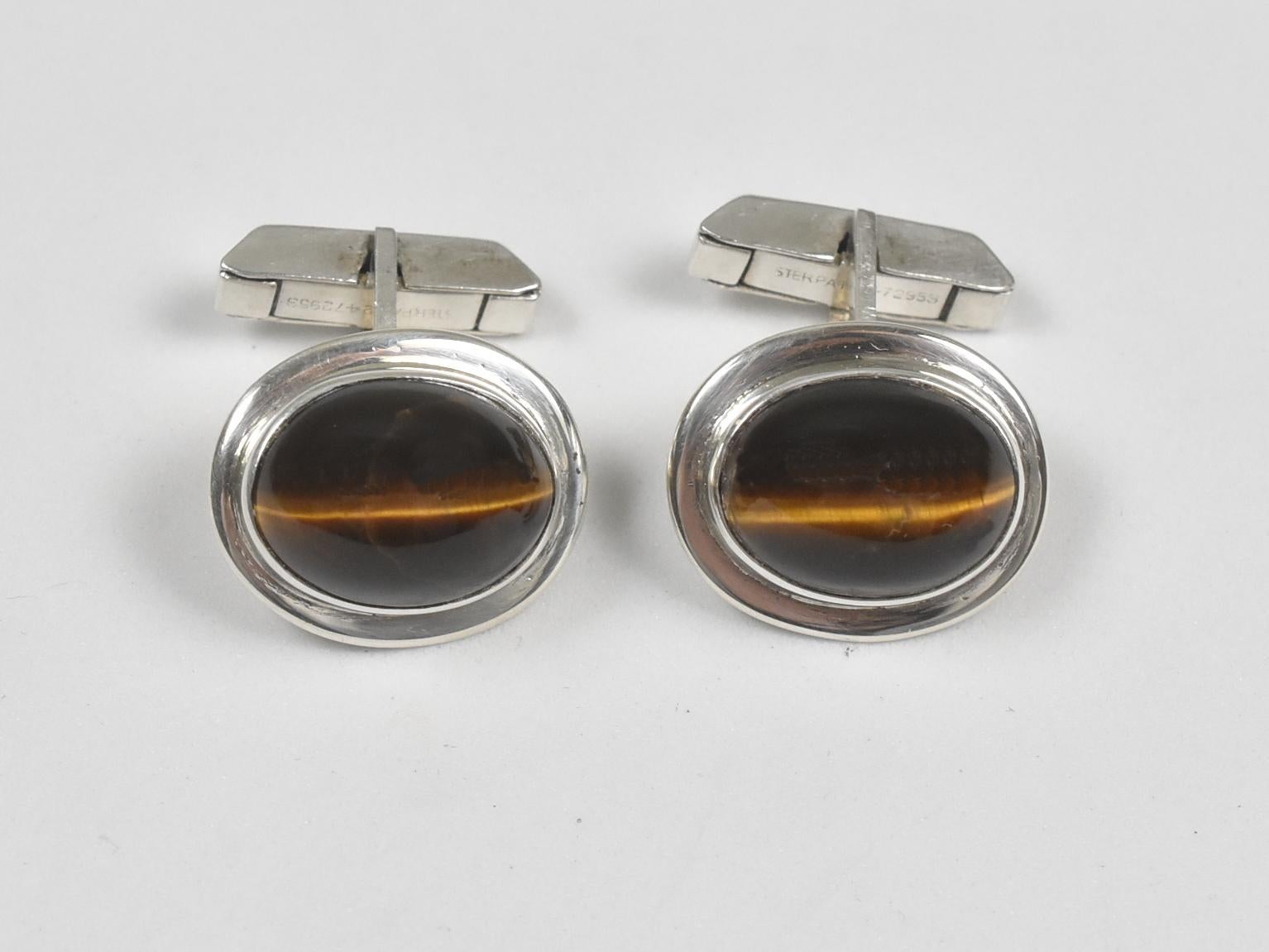 Oval tiger-eye sterling silver cabochon cuff links. Measures: 3 cm x 1.7 cm, marked sterling, stone measures: 1.6 cm x 1.1 cm, 14.8 grams total weight. Overall, in great condition.