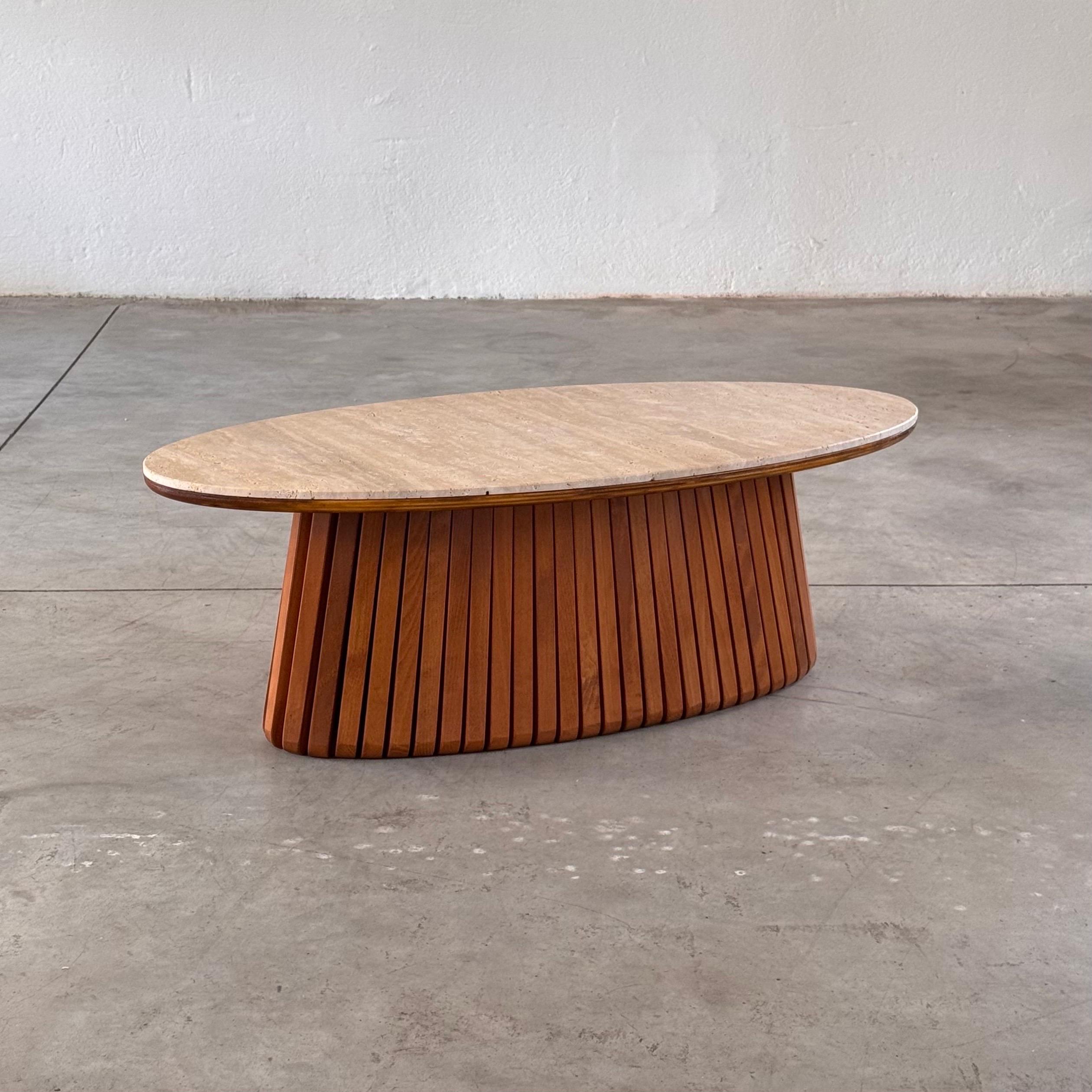 A refined and contemporary take on sculptural Italian design, this oval coffee table features a hand-finished travertine top resting on a striking slatted ashwood base.
Entirely crafted by hand without the use of industrial machinery, the piece
