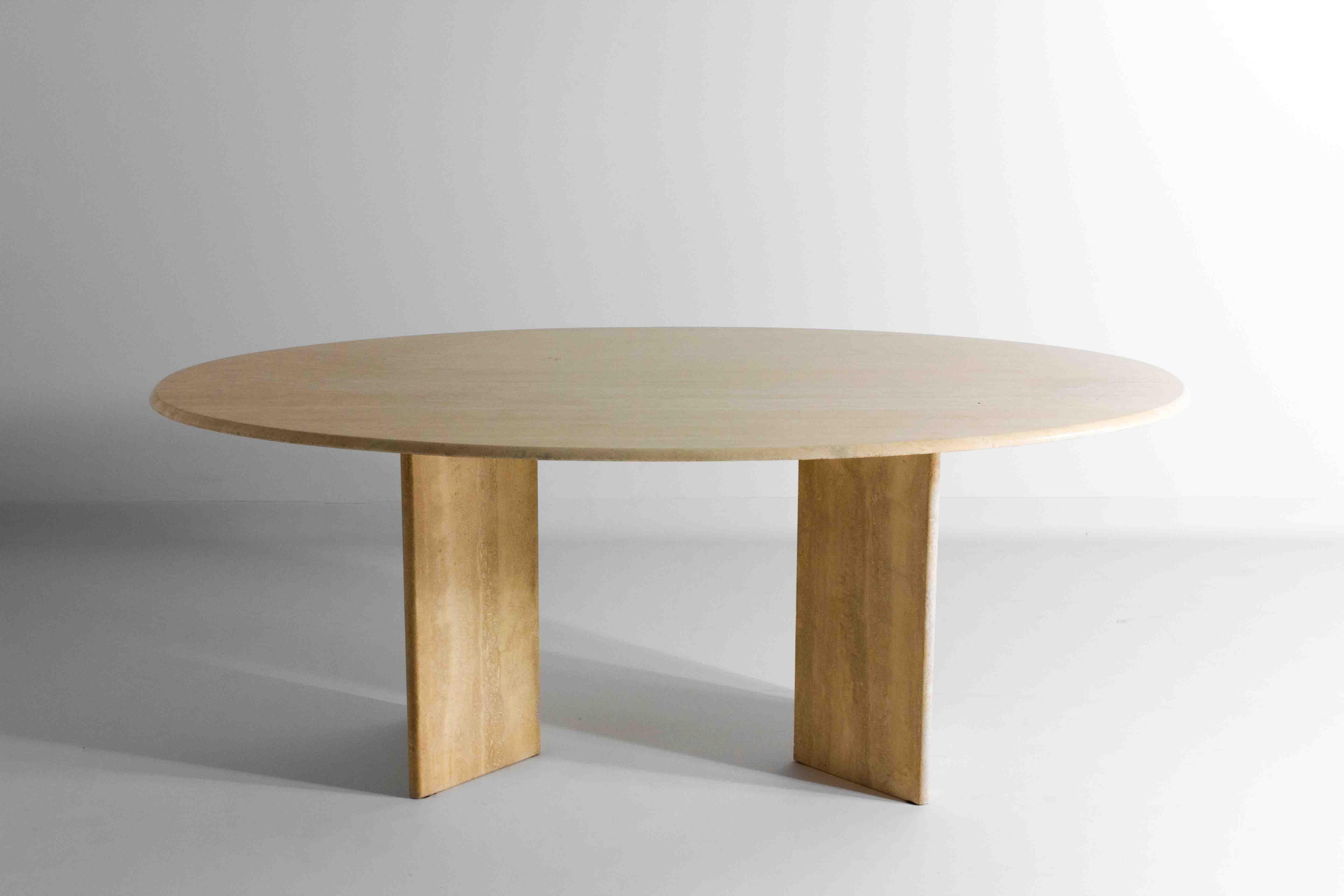 This 1970s Italian oval travertine dining table exudes a minimalist elegance with its smooth, clean lines and natural, light-toned stone construction. The table’s substantial oval top sits confidently on two robust, cornered feet which can be moved