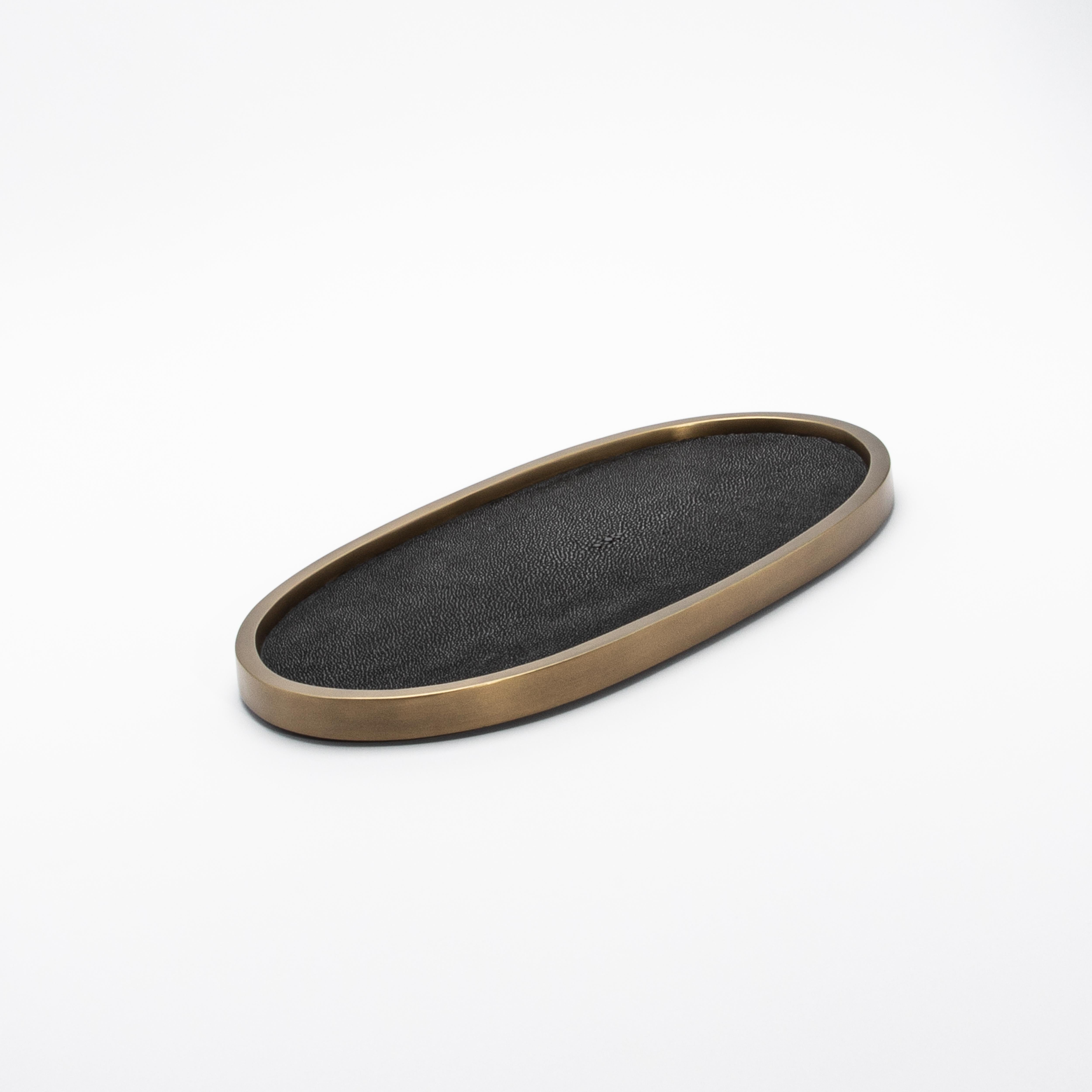Le plateau ovale Kifu Paris en galuchat noir illustre le luxe contemporain avec sa surface texturée, fabriquée à la main, et son design épuré et minimaliste. Le somptueux galuchat noir évoque une élégance raffinée et tactile, sa surface subtilement