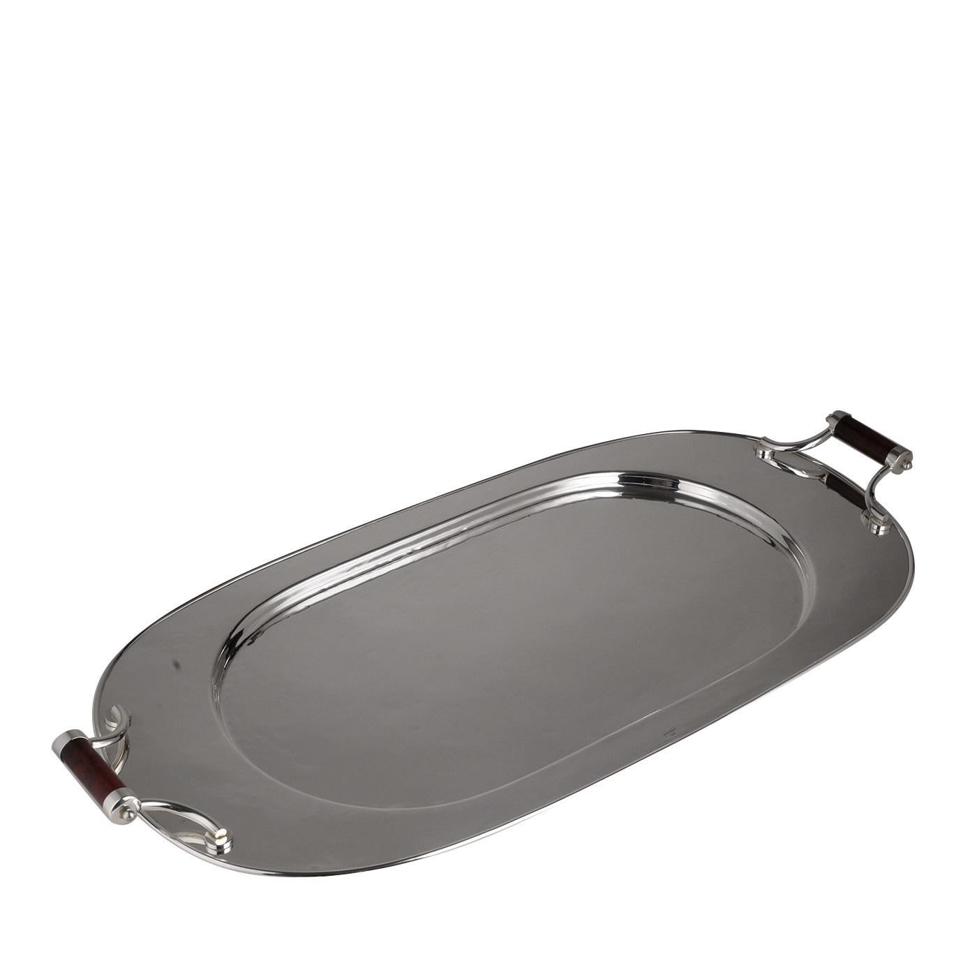 This oval tray is made of metal with a silver plated finish that gives it a cool, precious glow. The Classic design and exquisite craftsmanship make it an ideal object of functional decor in an elegant dining room or living room. The simple but