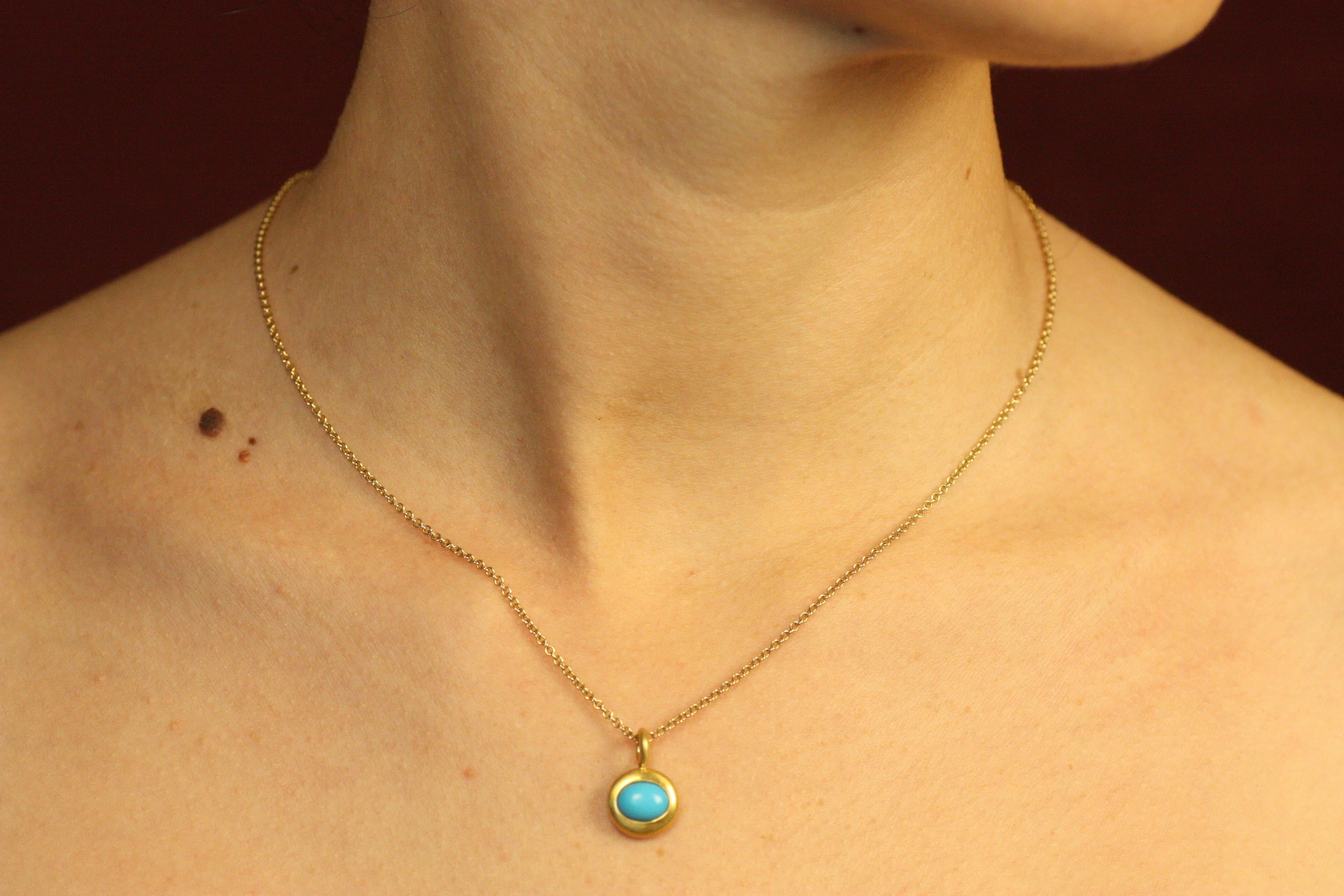 This bezeled charm pendant features an oval turquoise stone, wrapped in rich 22K yellow gold. The bright pop of color paired with the earthy gold makes for a beautifully balanced piece, perfect worn on its own or layered with other charm necklaces.