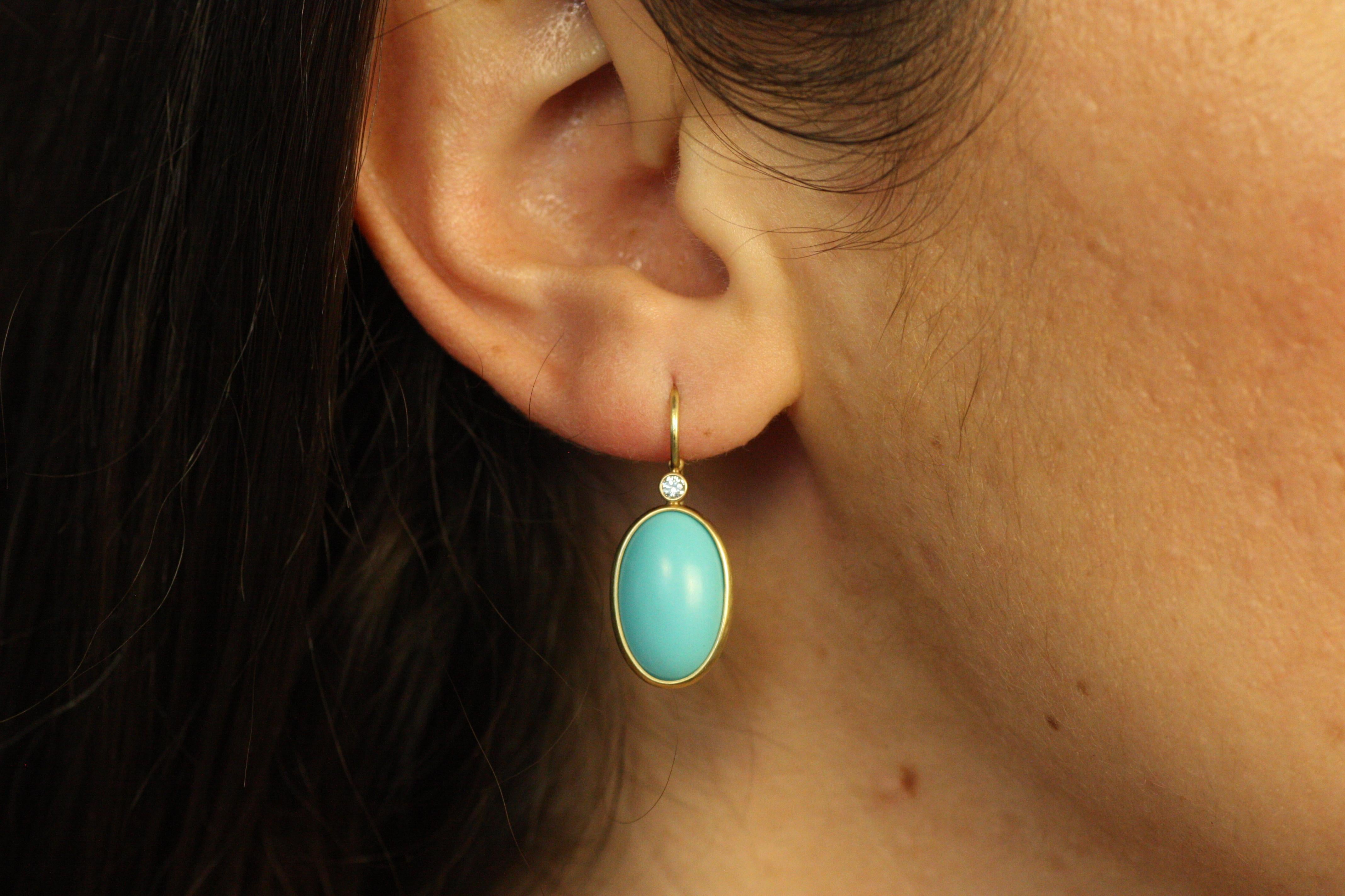 Ces boucles d'oreilles en or jaune 18 carats sont ornées de belles turquoises ovales serties en chaton et rehaussées de diamants étincelants. Fabriquées à la main à la perfection, ces boucles d'oreilles offrent un look vibrant et intemporel, idéal