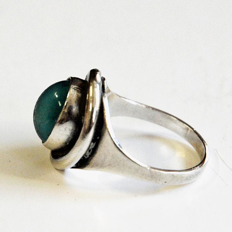 Decorative and lovely vintage silvering with a shiny medium oval turquoise stone designed by Sven Holmström, Sweden, 1960s.

Stamped: 935 and SH. Measures: Inner diameter is 16.5 mm, Size of stone: 10 mm x 8 mm. Scandinavian design. Very nice and