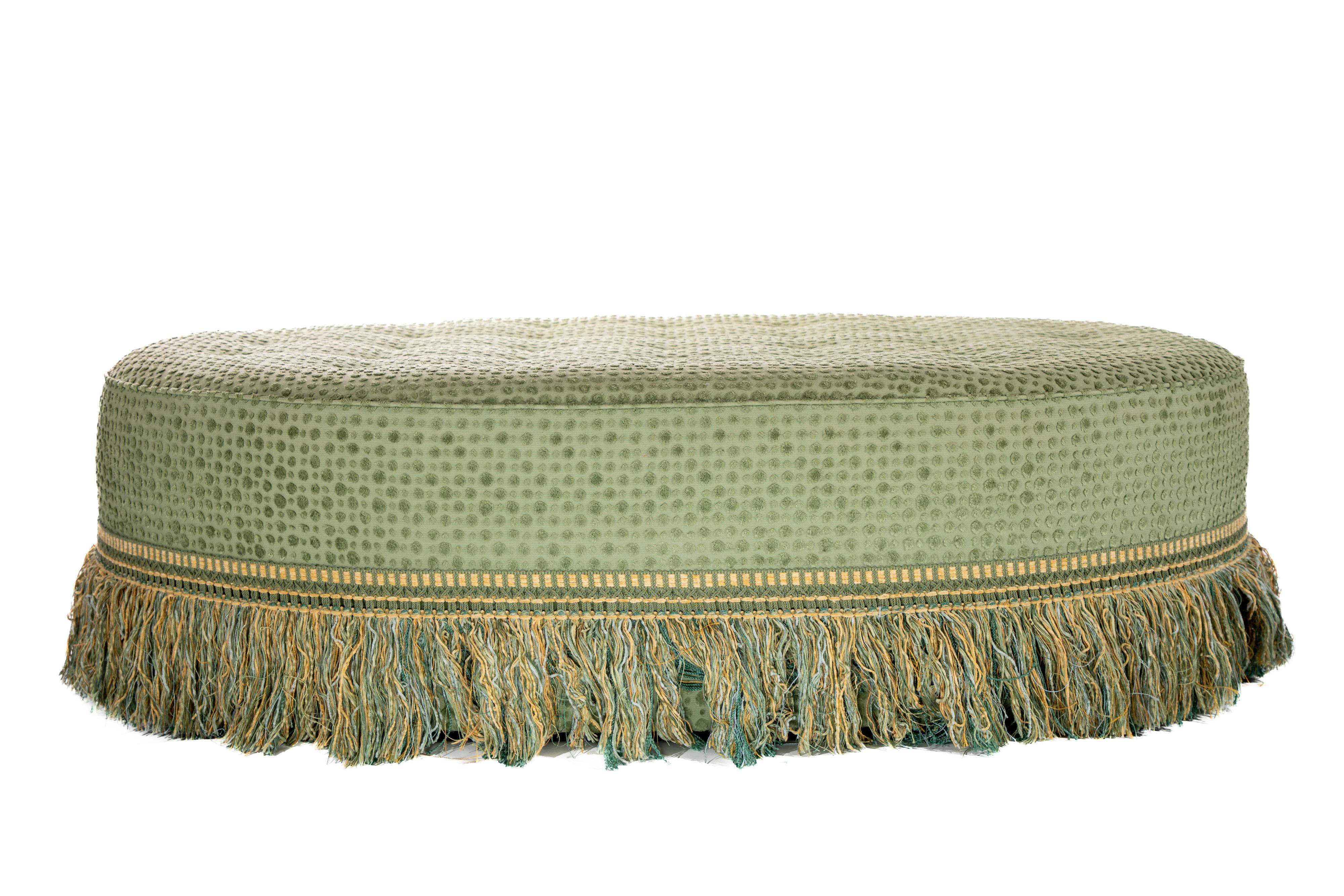 Oval tufted ottoman with fringe detail at skirt.  Upholstered in Robert Allen Dewdrop Fern Fabric