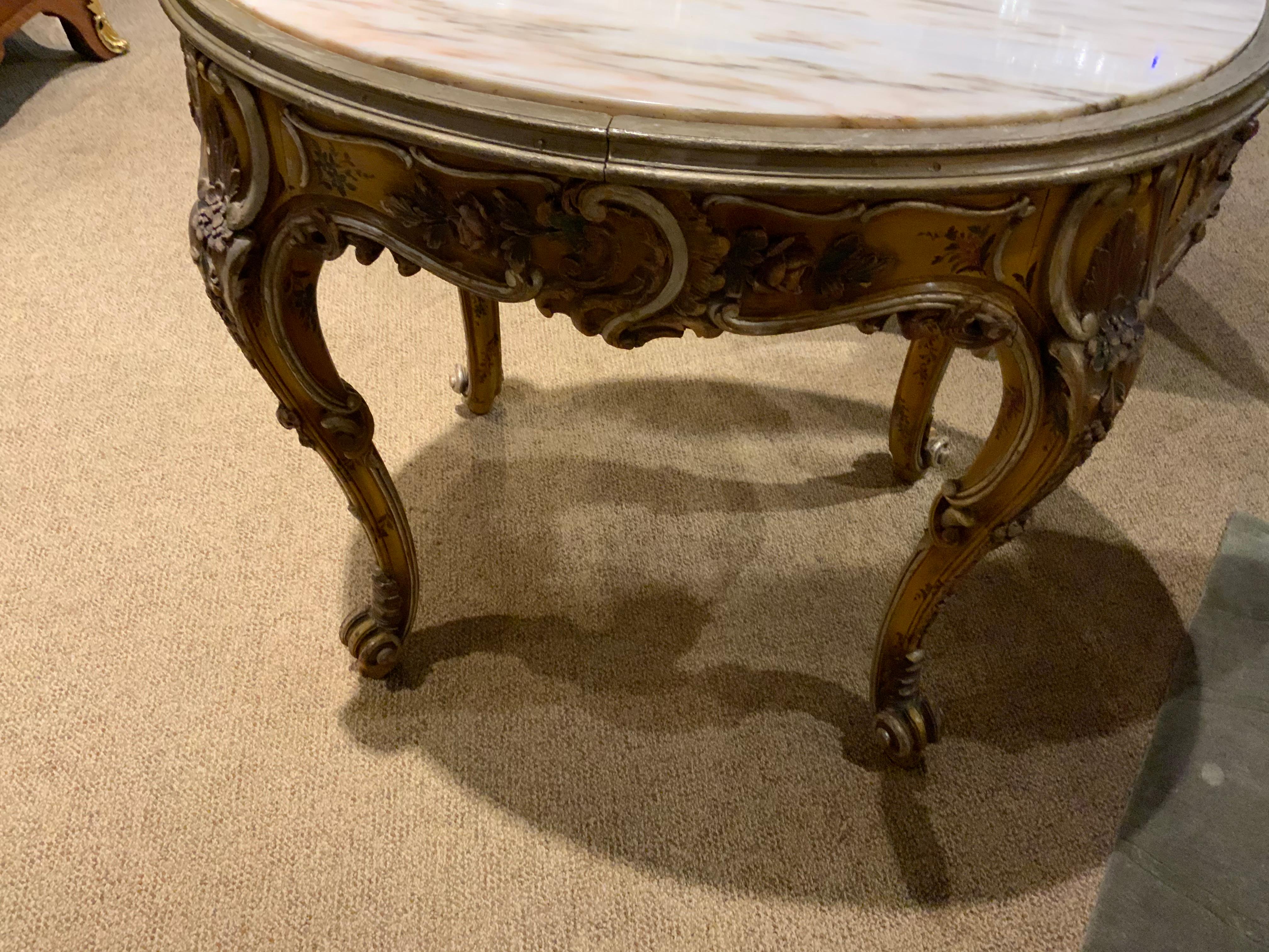 Venetian table that is carved with a floral and Foliate design in gold background and highlighted
With silver edges. The foliate design is green with pale rouge flowers. The legs are scrolling
In the cabriole Louis XV style.