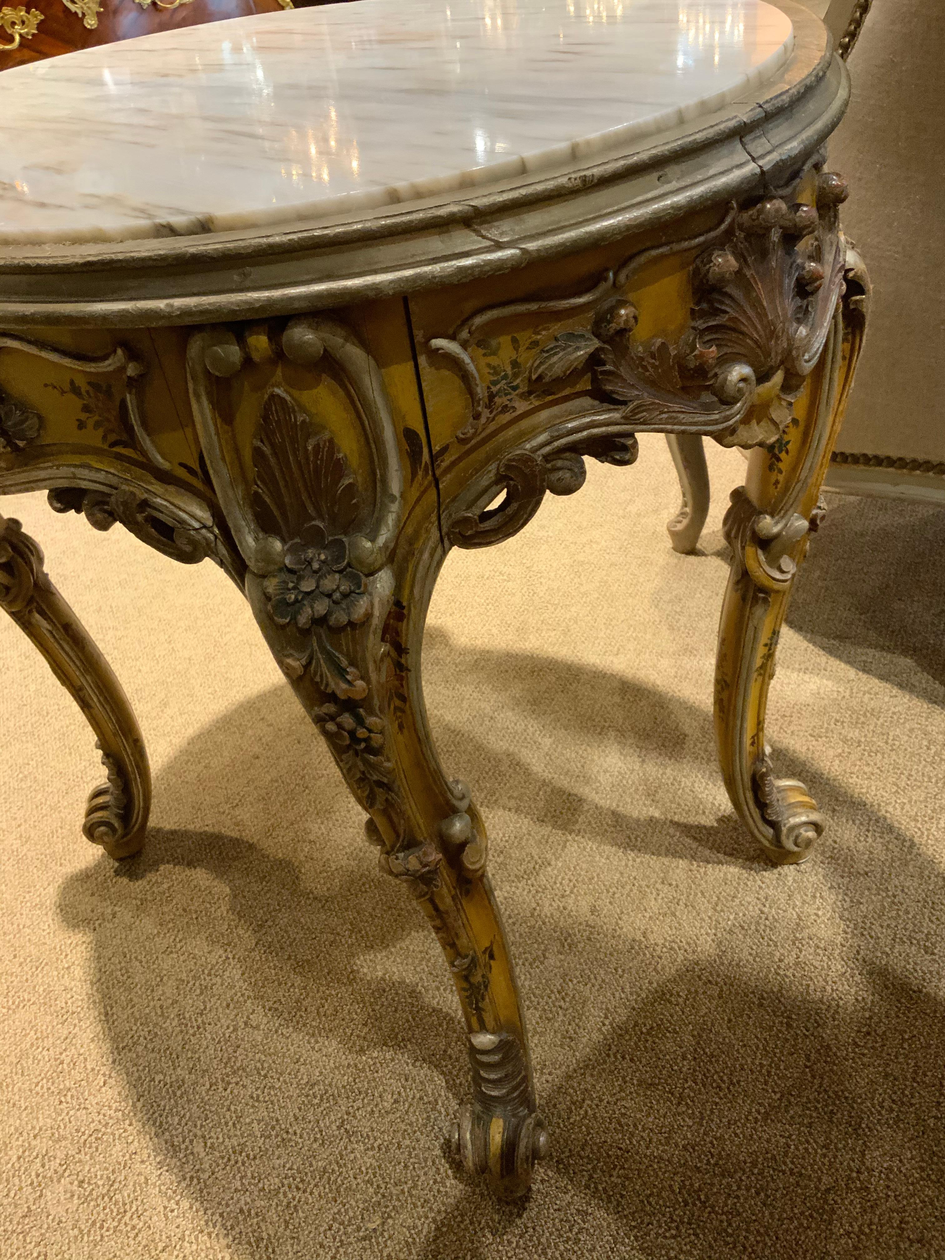 Italian Oval Venetian Carved and Polychrome Table with a Cream, Gold and Pale Gray Veins For Sale