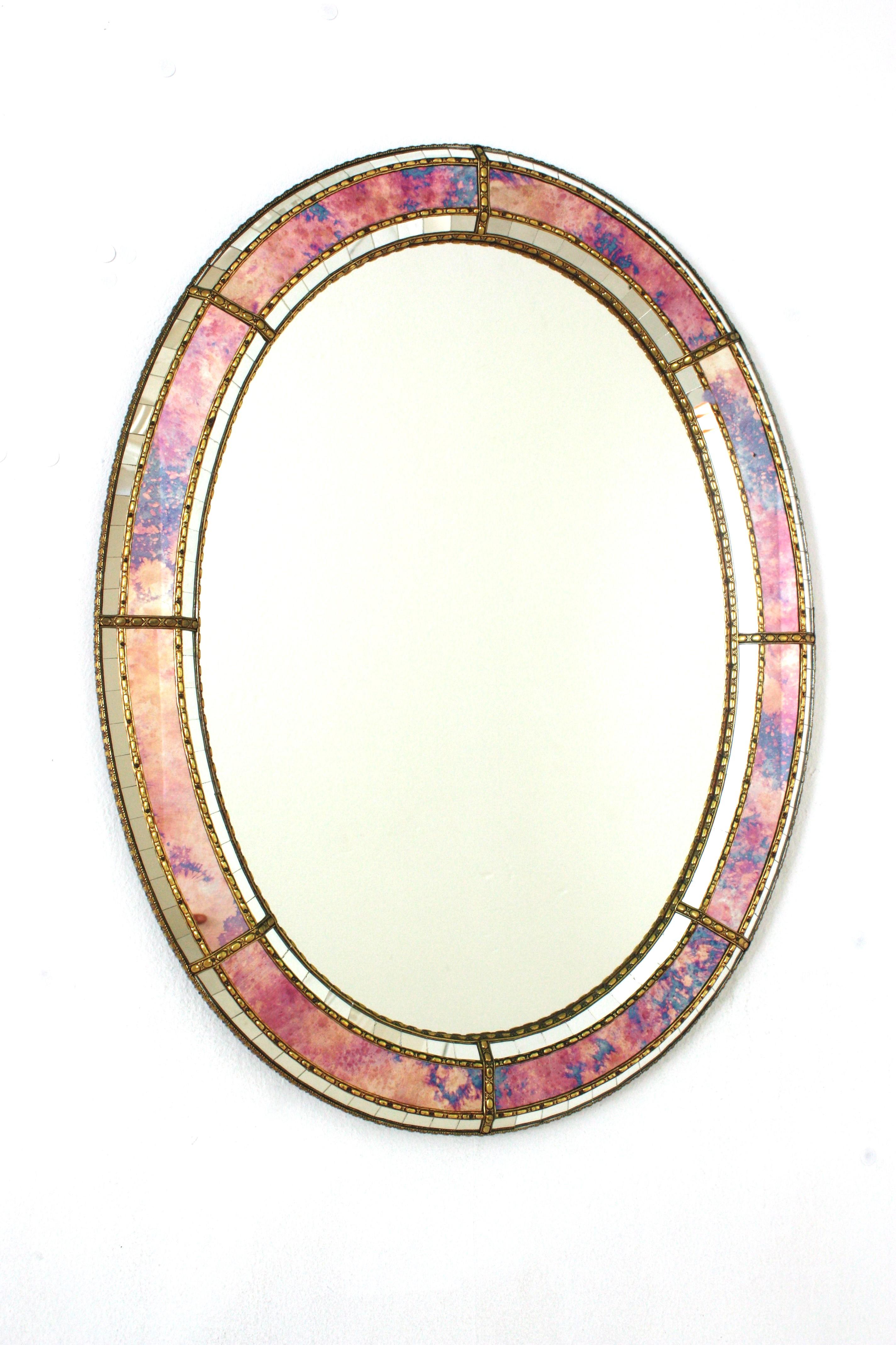 Elegant Venetian style Hollywood Regency oval mirror with iridiscent and mirror glass panels. Spain, 1960s
This glamorous mirror featuring a double layered mirror frame made of brass. Oval form with a frame that has two layers of decorative paneled
