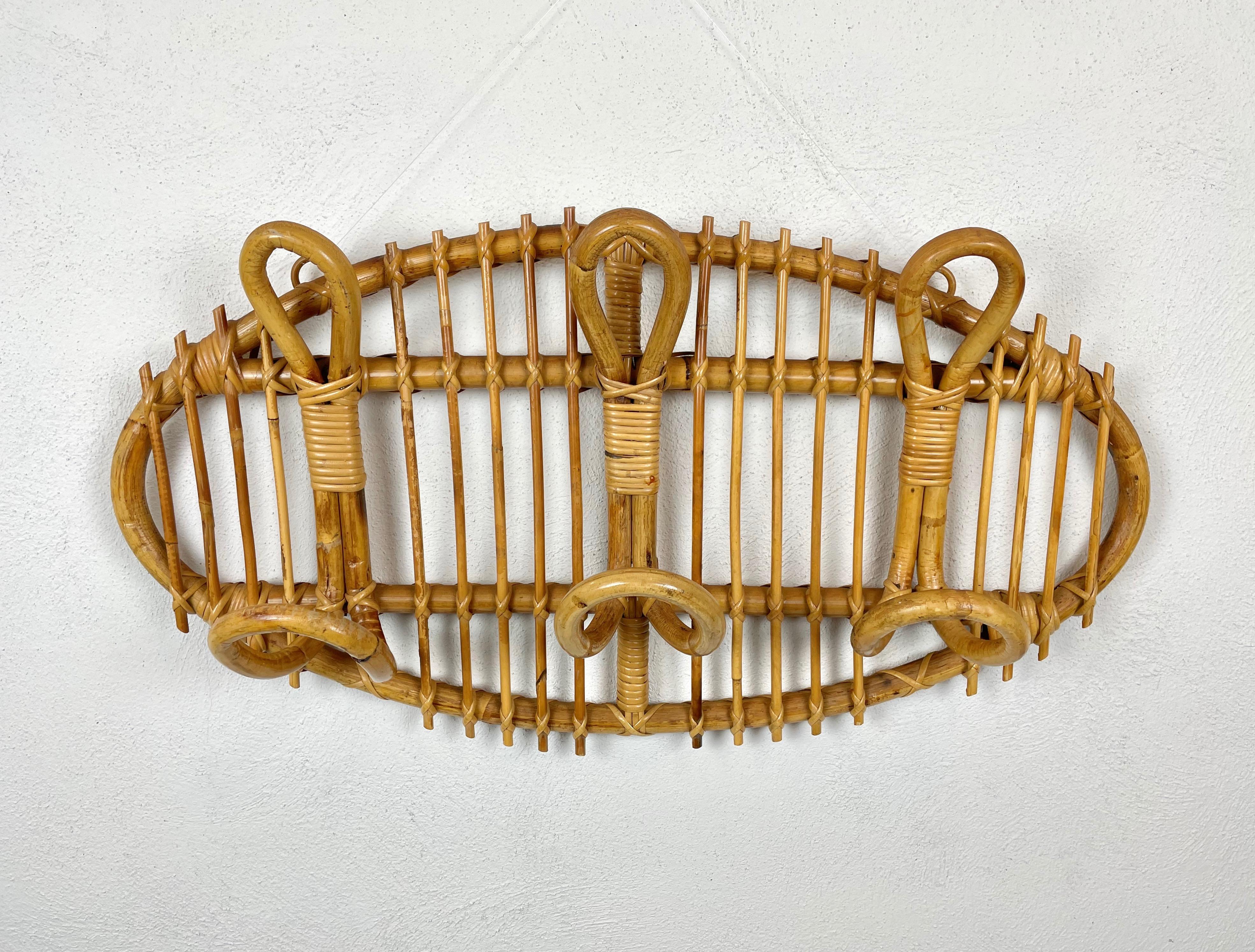 Oval coat rack stand in bamboo and rattan composed of three double hooks. Made in Italy in the 1960s.

 