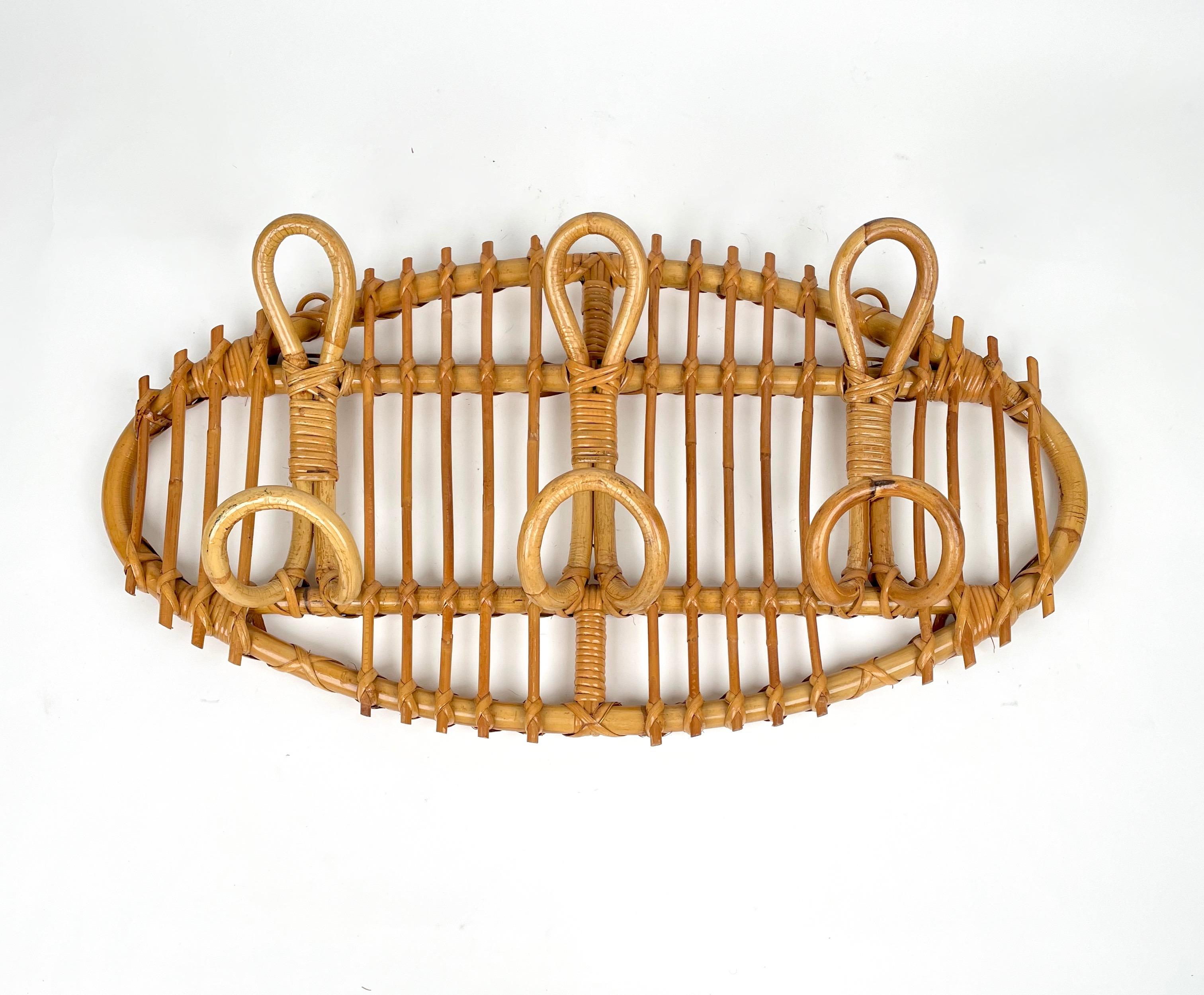 Oval coat rack stand in bamboo and rattan composed of three double hooks. 

Made in Italy in the 1960s.