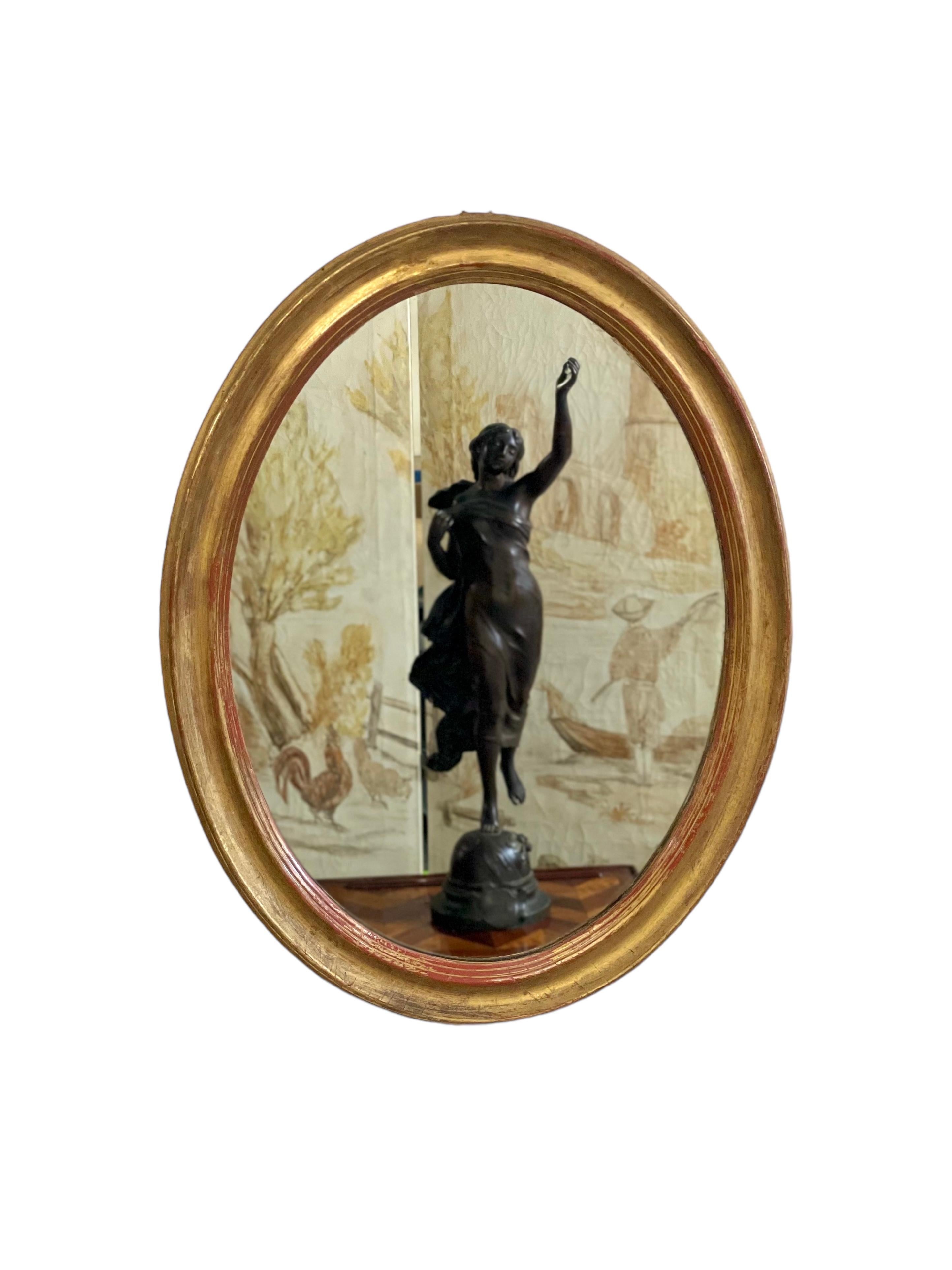 Français Miroir mural ovale en bois doré en vente