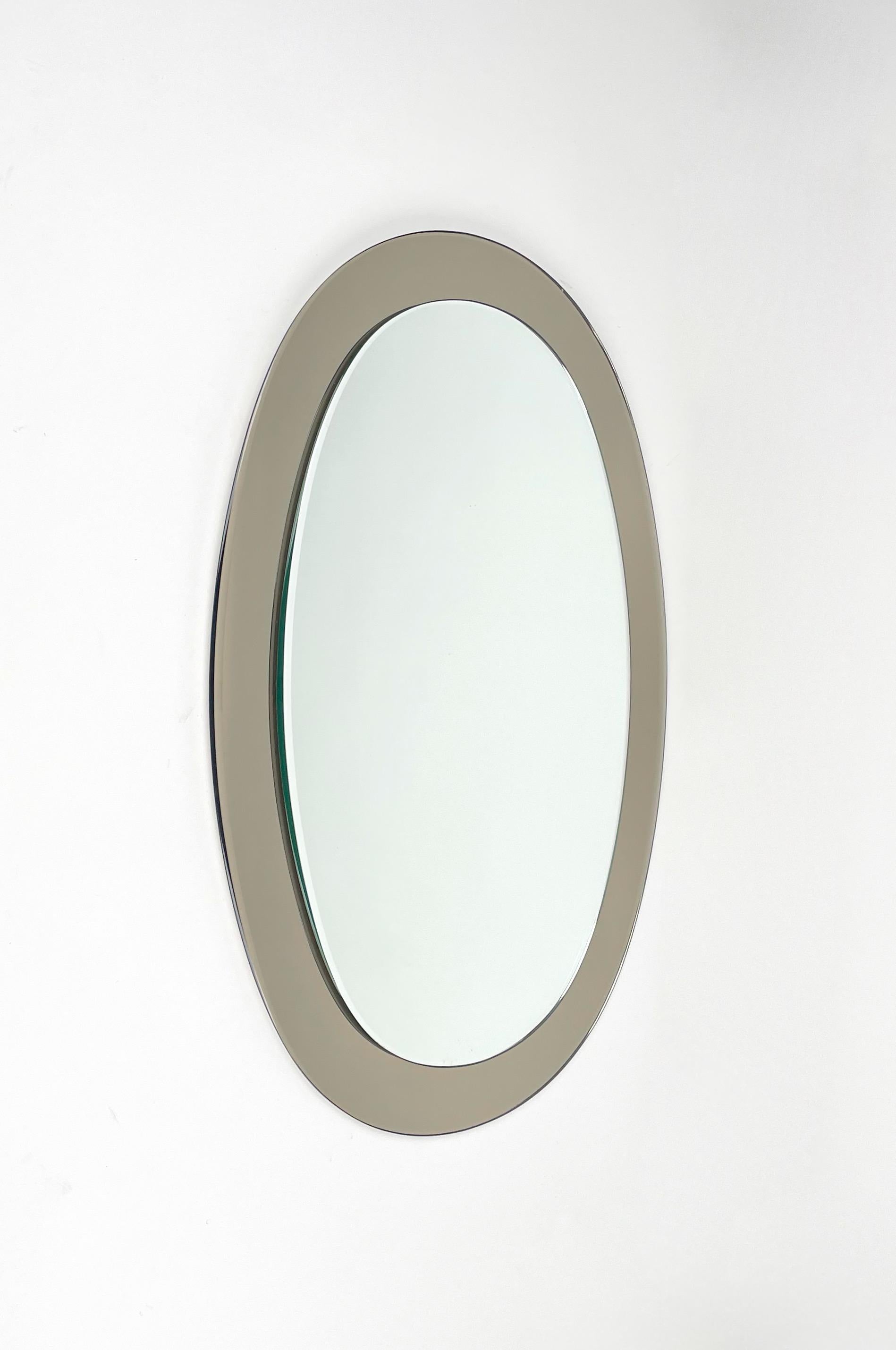 Oval wall mirror with grey frame by Sena Cristal. Made in Italy in the 1970s. 

The original label is still attached on the back of the mirror, as shown in photos.