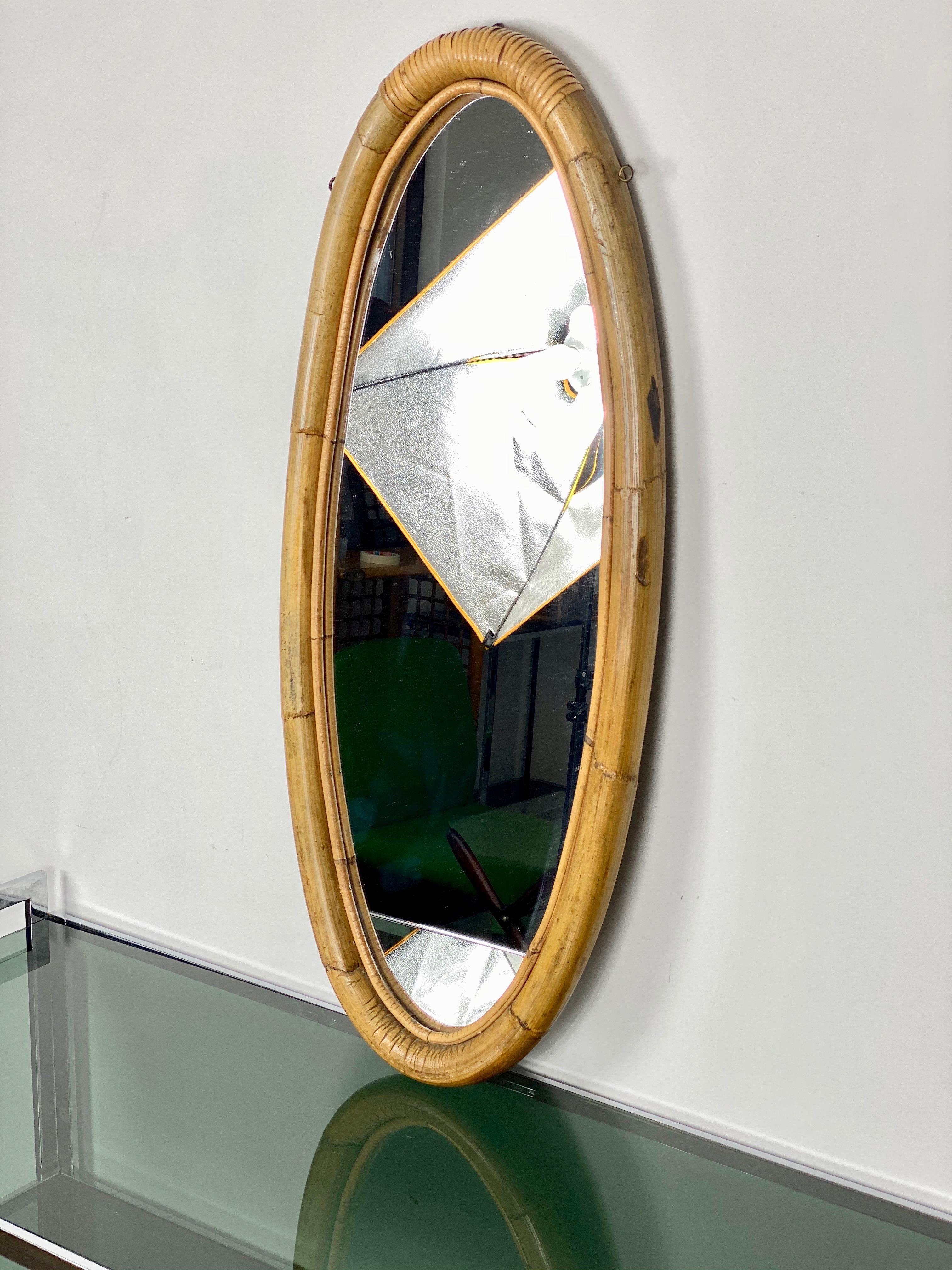 Oval long wall mirror framed in bamboo and rattan, a typical piece of the Italian 1960s style in the style of the designer Franco Albini.