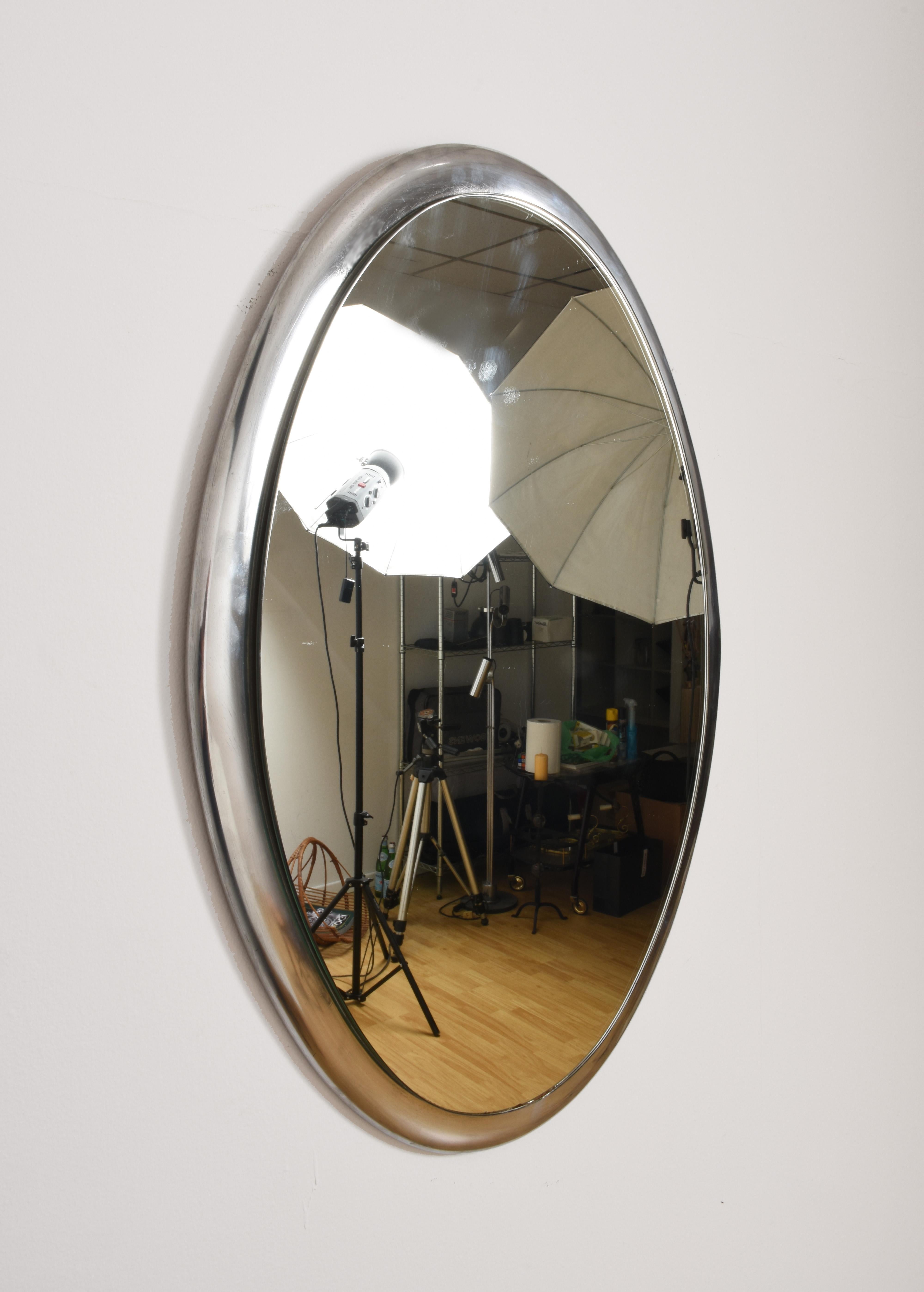 Oval-shaped mirror, the frame is very heavy metal (it could be cobalt). The mirror is in relief and this gives a deeper effect. It can be mounted either vertically or horizontally.