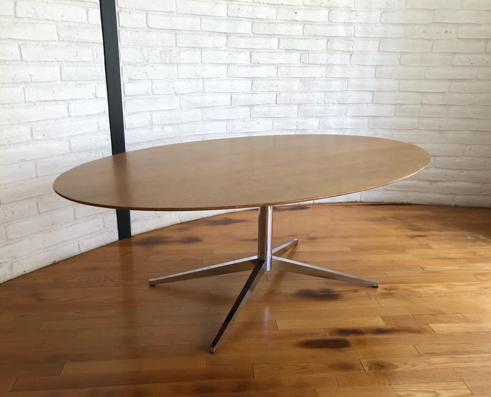 1960’s walnut oval dining table by Florence Knoll for Knoll.
In original condition with minor wear consistent with age. 
Retains knoll tag.