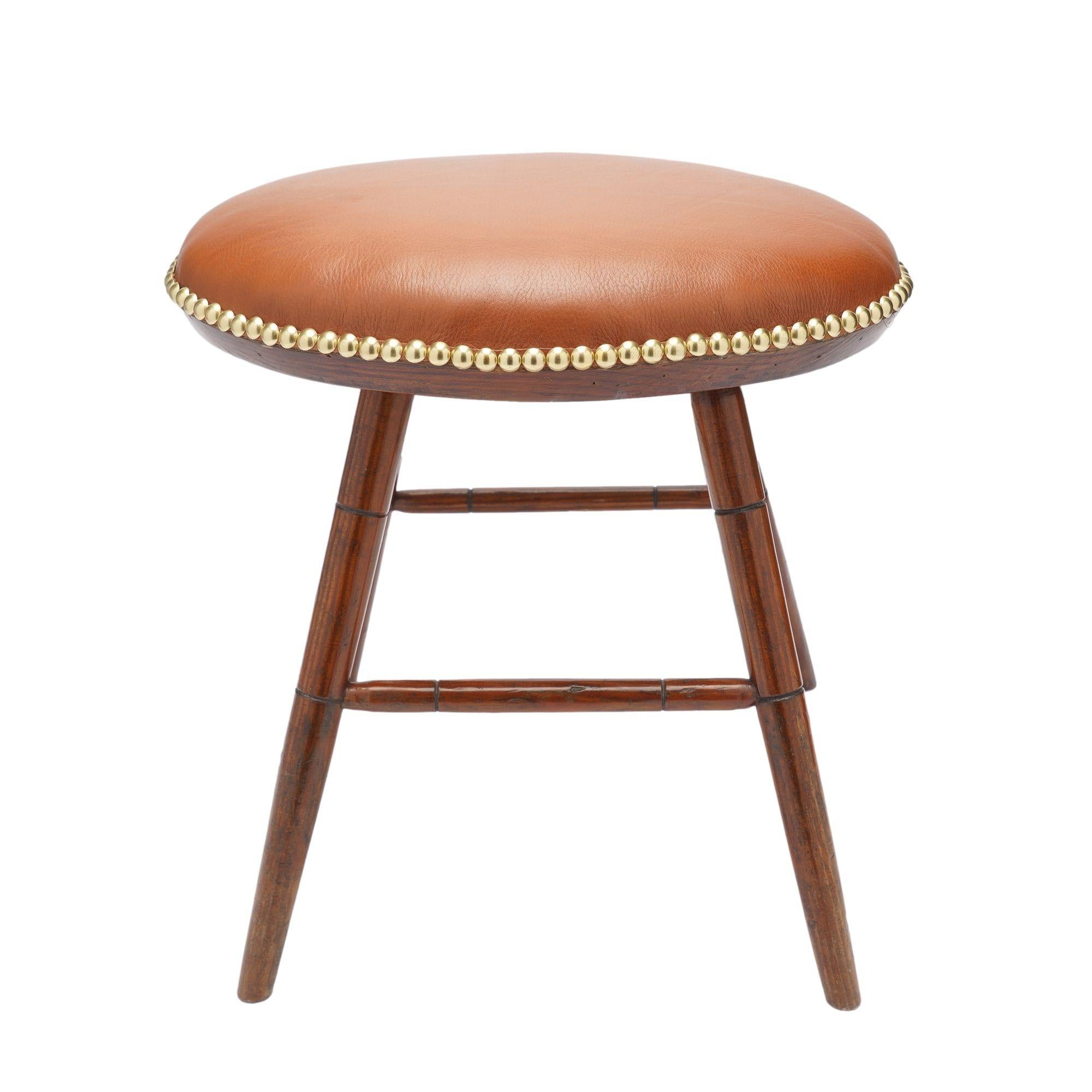Raro escabel Windsor de forma ovalada, con asiento de cuero tapizado y patas de bambú torneado, unidas por camillas en forma de 