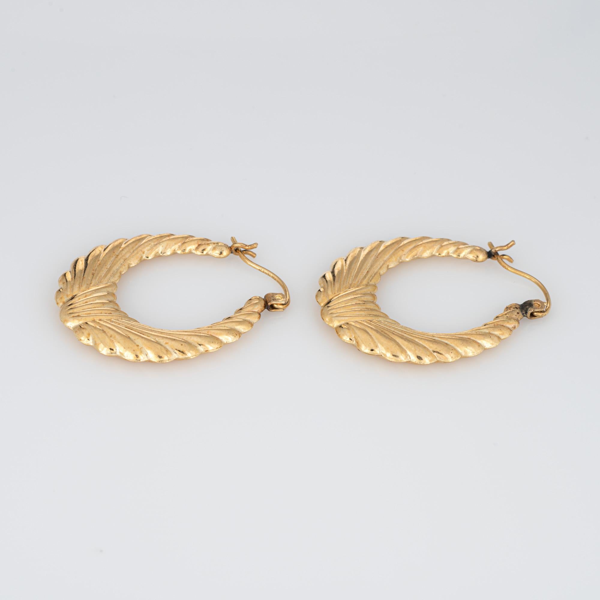Fine detailed pair of oval wreath hoop earrings crafted in 14k yellow gold (circa 1980s to 1990s).

The stylish earrings feature a wreath design. The hollow earrings offer a lightweight feel for a comfortable fit on the earlobe. The earrings are