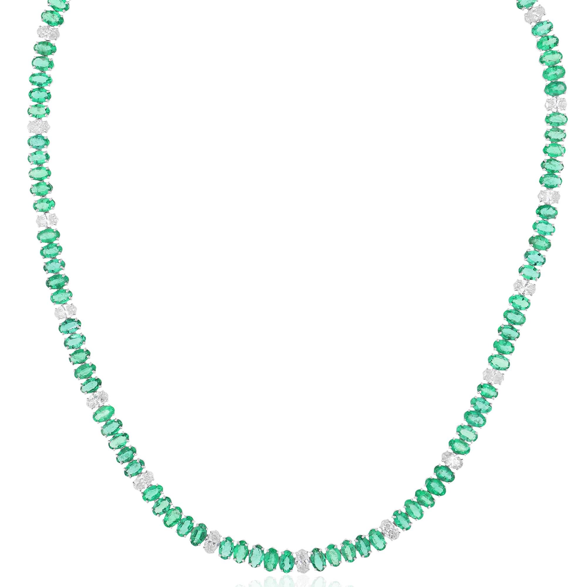 Surrounding the emerald are shimmering diamonds, meticulously set to enhance its beauty and create a mesmerizing display of light. The diamonds add a touch of glamour and sparkle to the design, accentuating the lush green hue of the emerald and