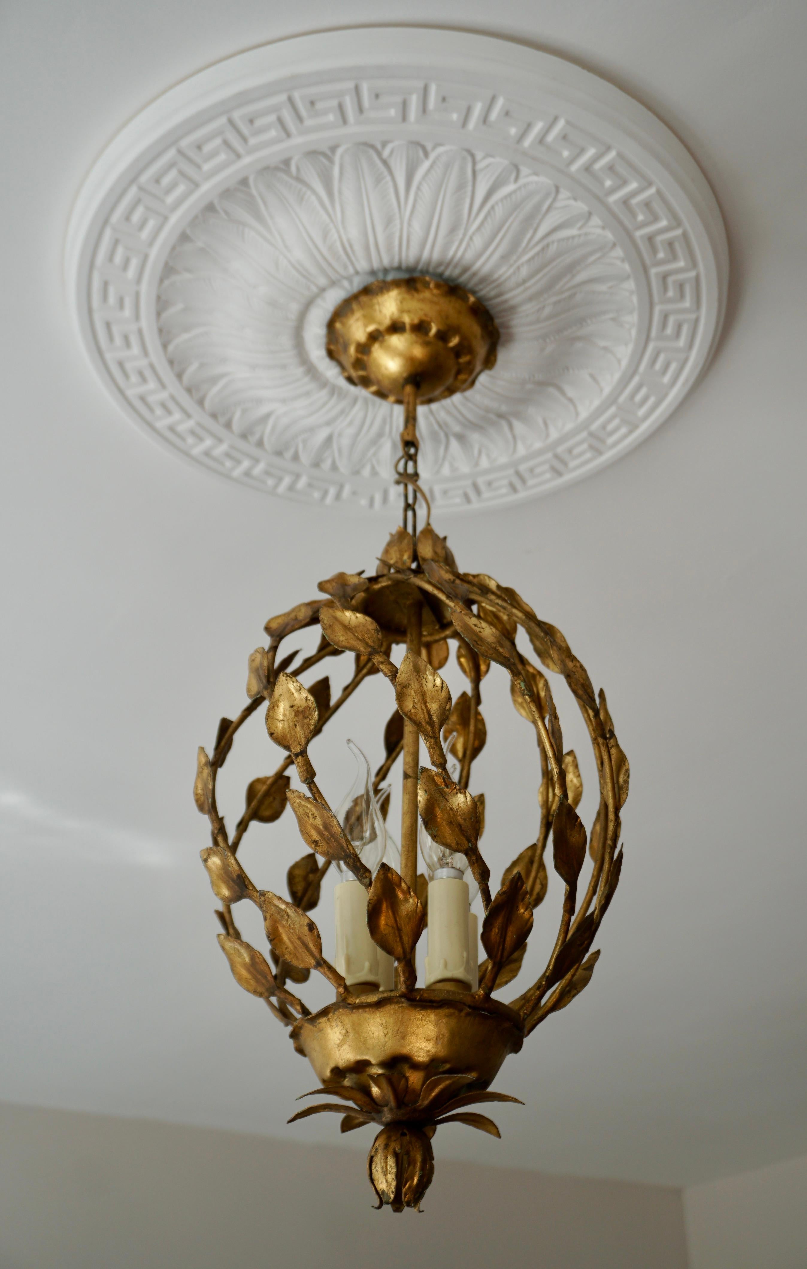 A Hollywood Regency style four-light gilt metal chandelier with tôle palm fronds.In working order.
Very good original vintage condition. 

Diameter 11