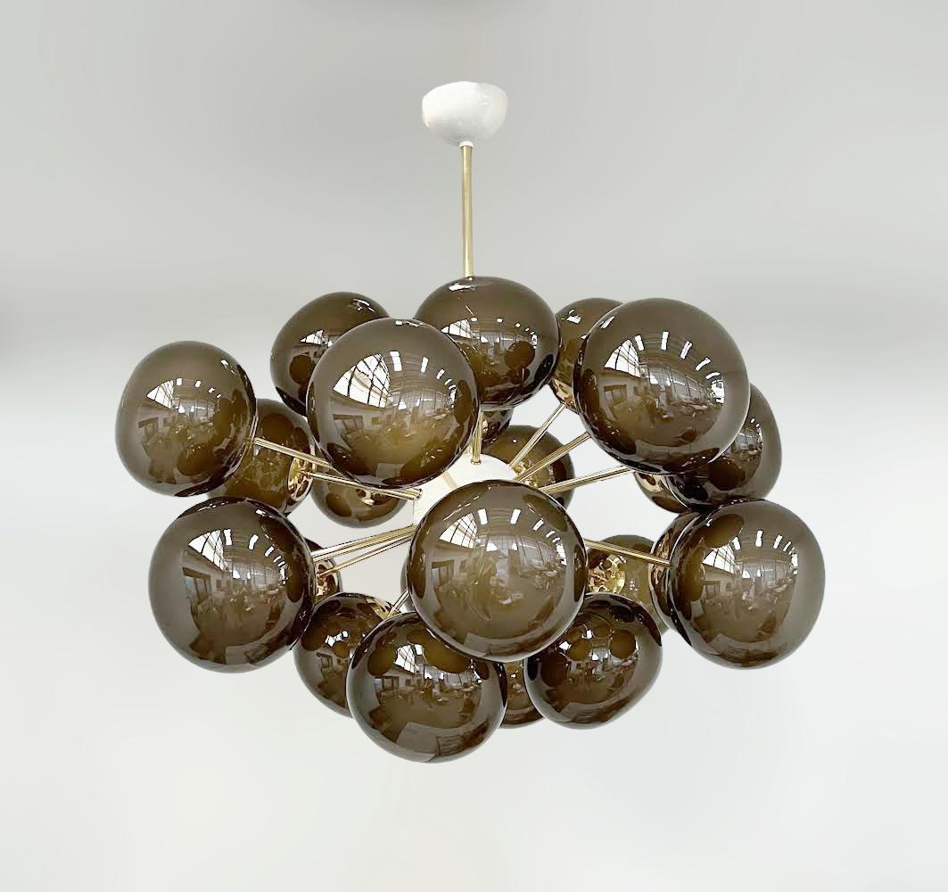 Lampadario italiano di forma ovale con paralumi in vetro di Murano smerigliato e fumé montati su una struttura in ottone / disegnato da Fabio Bergomi per FABIO LTD / Made in Italy
24 luci / tipo E12 o E14 / max 40W ciascuna
Misure: Diametro 36