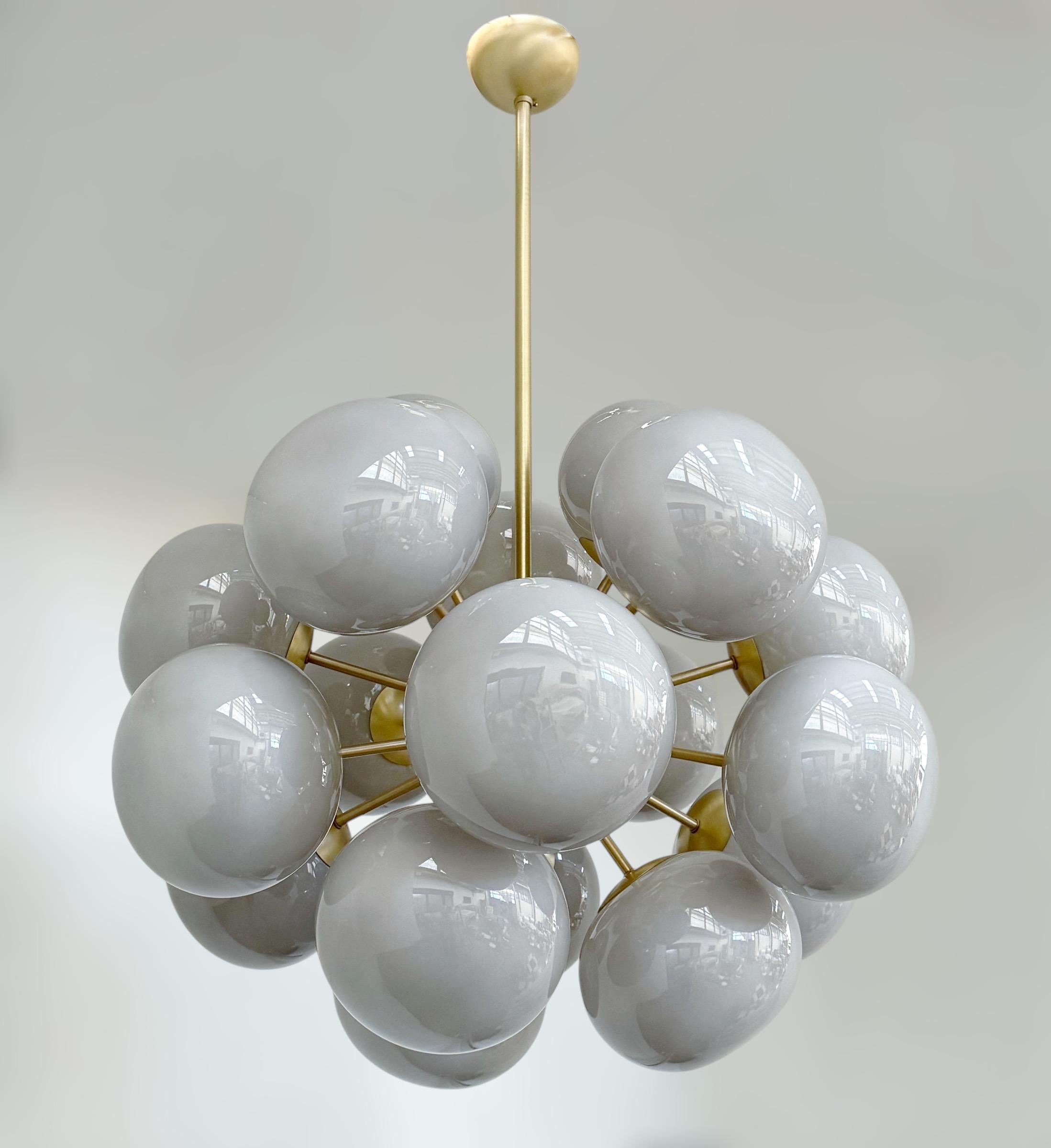 Lampadario italiano di forma ovale con paralumi in vetro grigio di Murano montati su una struttura in ottone / disegnato da Fabio Bergomi per FABIO LTD / Made in Italy
18 luci / tipo E12 o E14 / max 40W ciascuna
Misure: Diametro di 28 pollici,