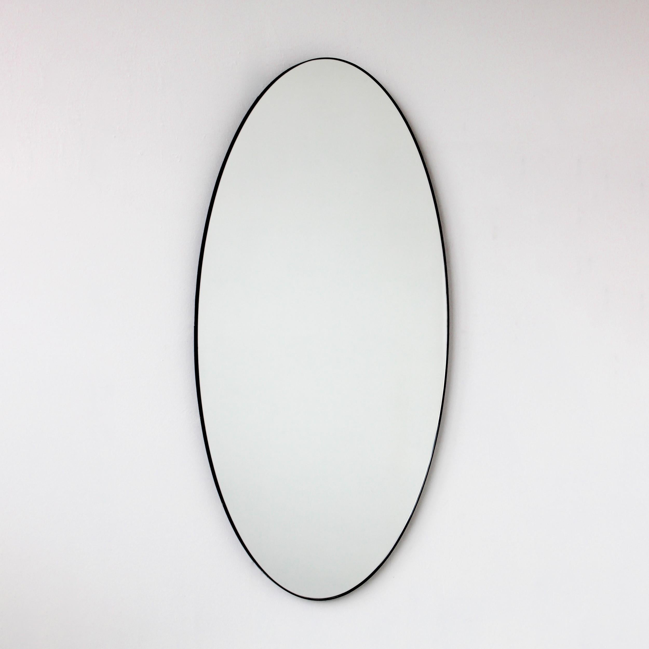 Delizioso specchio ovale di grandi dimensioni con una cornice contemporanea in alluminio verniciato a polvere di colore nero. Progettato e realizzato a mano a Londra, nel Regno Unito. Questo specchio è completamente personalizzabile. 

I nostri