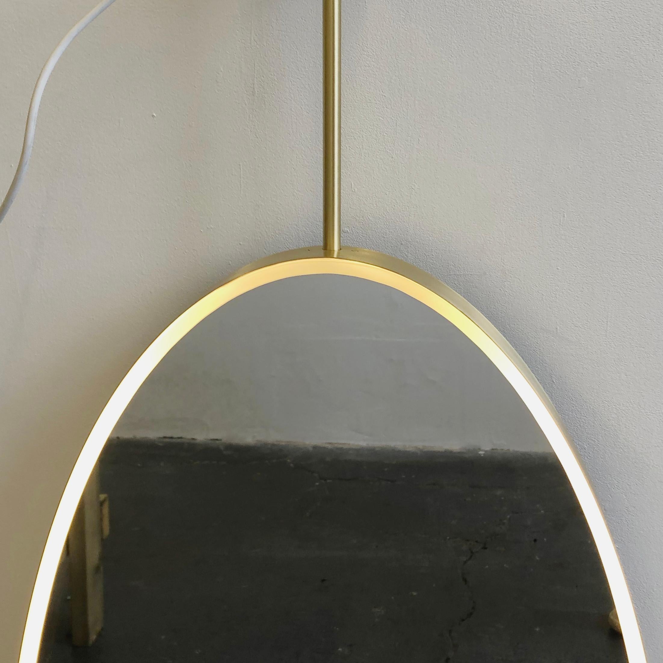 Britannique Miroir Ovalis ovale suspendu au plafond avec cadre en laiton et éclairage avant en vente