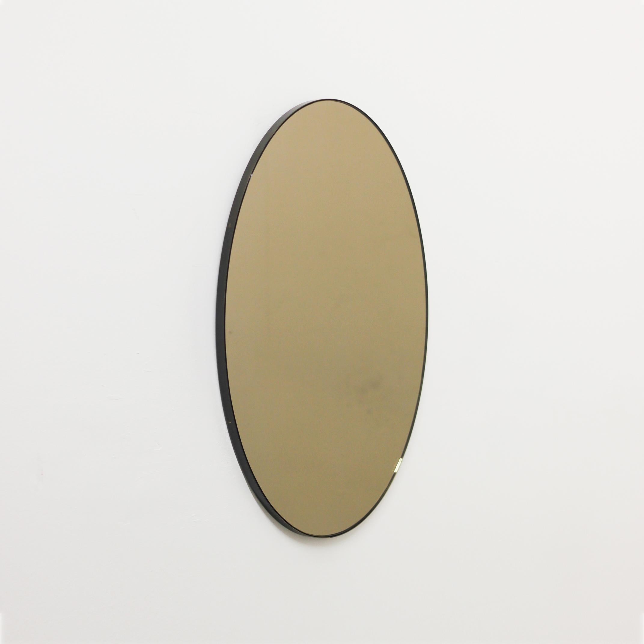 Contemporary oval bronze tinted mirror with an elegant bronze patina brass frame. Designed and handcrafted in London, UK. Supplied fully fitted with a specialist hanging system for an easy installation.

This mirror is fully customisable. Shipped