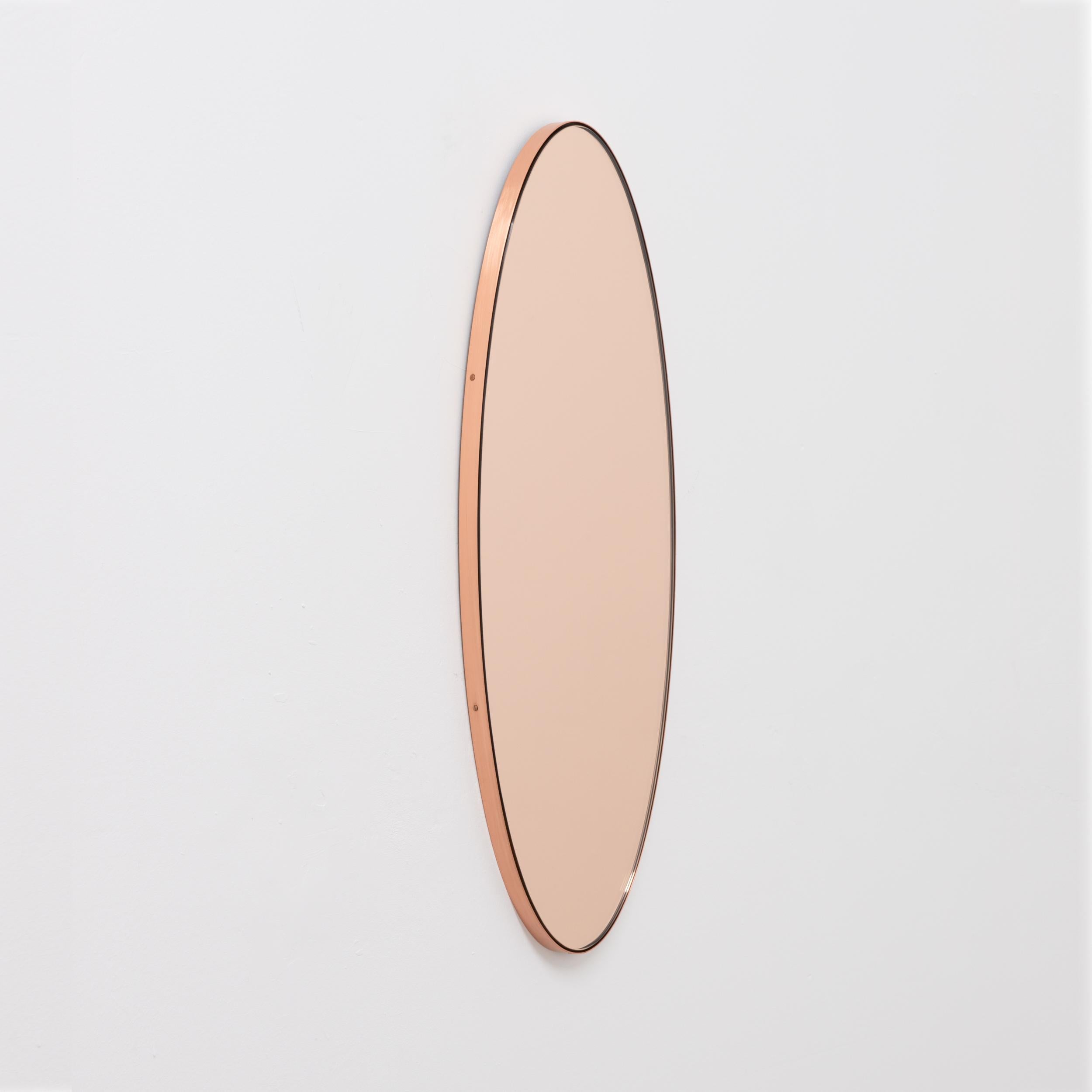 Contemporary oval shaped rose gold/peach mirror with an elegant copper frame. Designed and handcrafted in London, UK.

Medium, large and extra-large (37cm x 56cm, 46cm x 71cm and 48cm x 97cm) mirrors are fitted with an ingenious French cleat (split