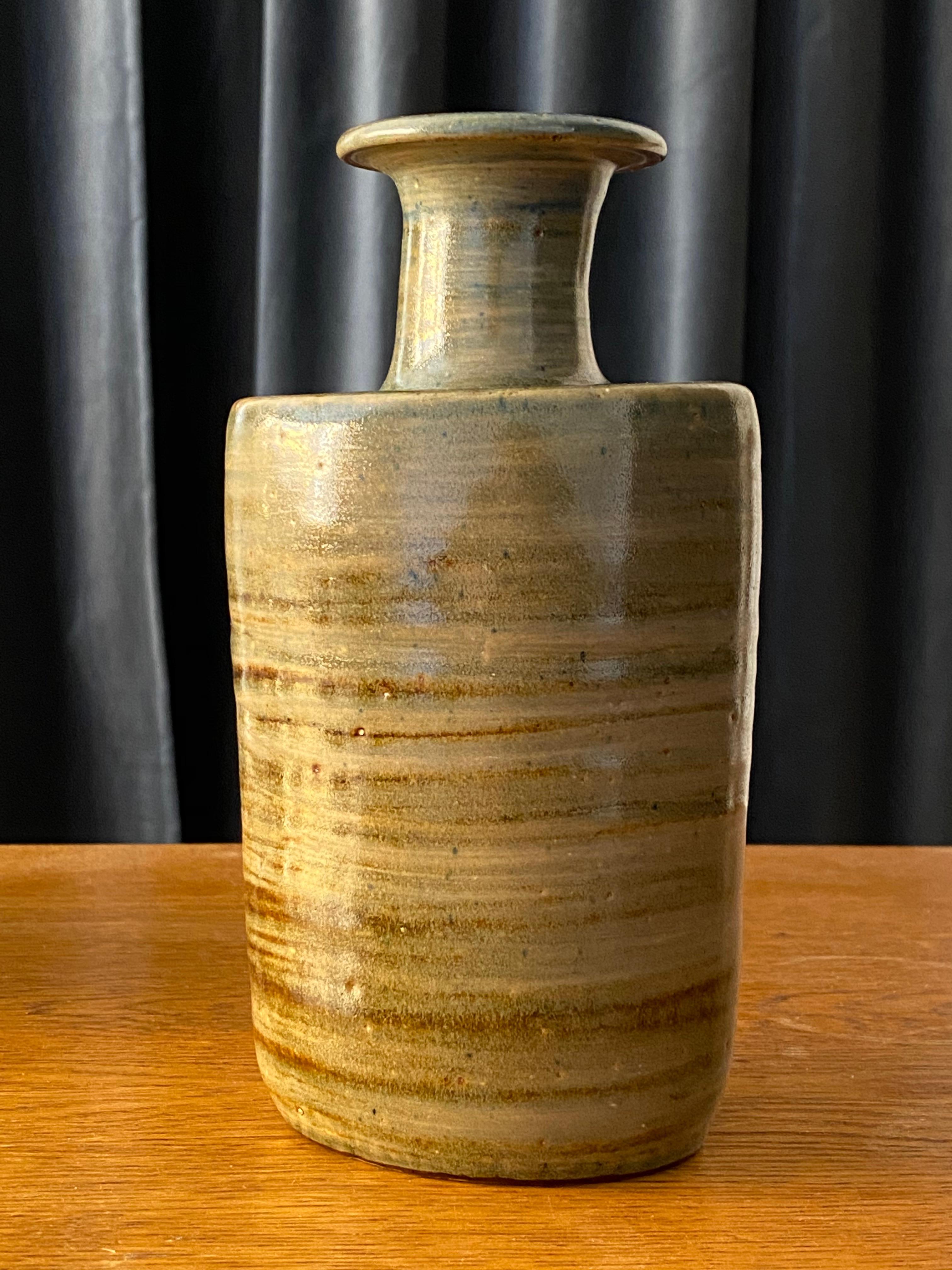 A studio vase by Swedish ceramicist Ovar Nilsson, who left large scale ceramic producer Höganäs in 1940 to pursue his own artistic practice. His work was subject to an exhibition at Höganäs Museum, Sweden in 2004. In grey / brown glaze with hints of