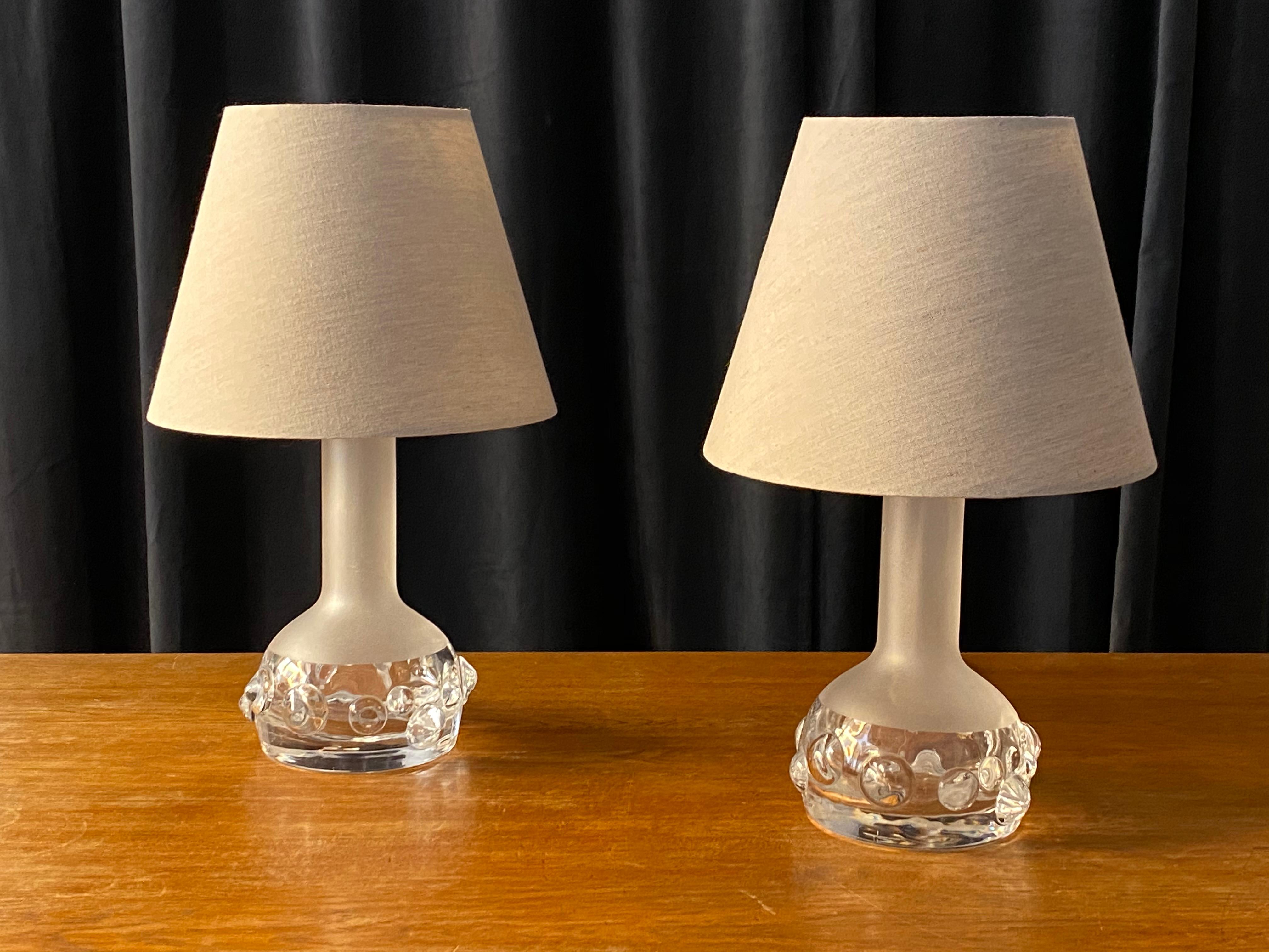 A pair of organic table lamps. In partially frosted glass. Designed by Ove Sandberg for iconic Swedish glassworks firm Kosta. With later linen screens. 

Other designers of the period include Josef Frank, Lisa Johansson-Pape, Tapio Wirkkala, Carl