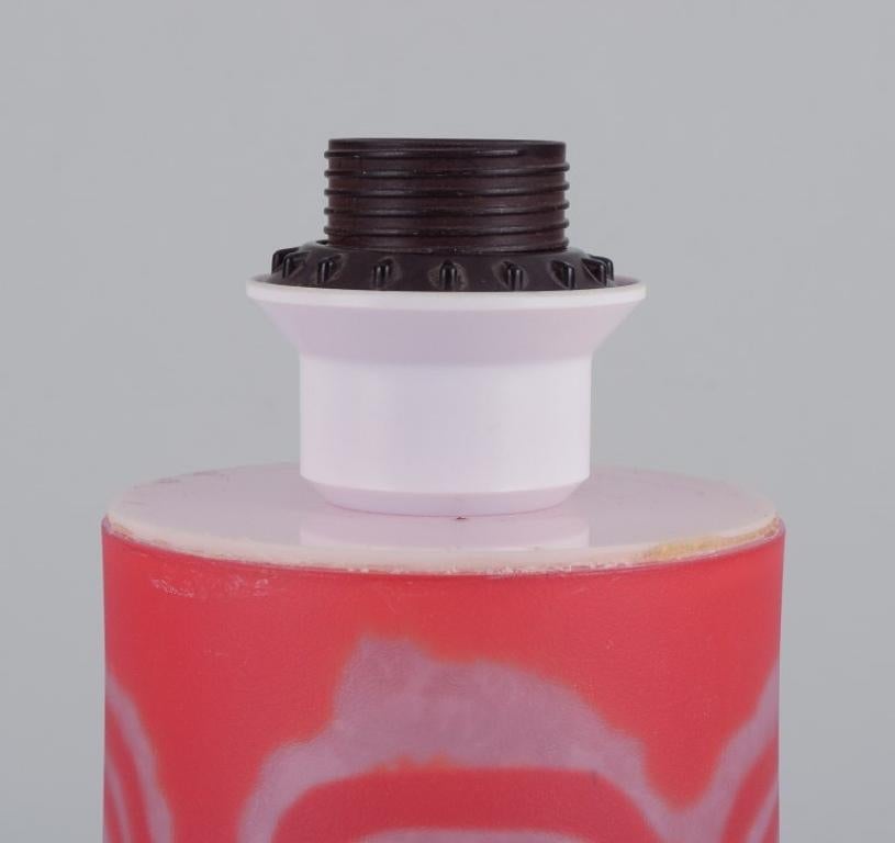 Ove Sandeberg pour Kosta Boda, Suède. 
Lampe de table en verre d'art de couleur orange.
Incrustation d'un motif abstrait.
1980s.
Signé.
Parfait état.
Dimensions : H 19,0 cm sans la prise x D 10,5 cm.