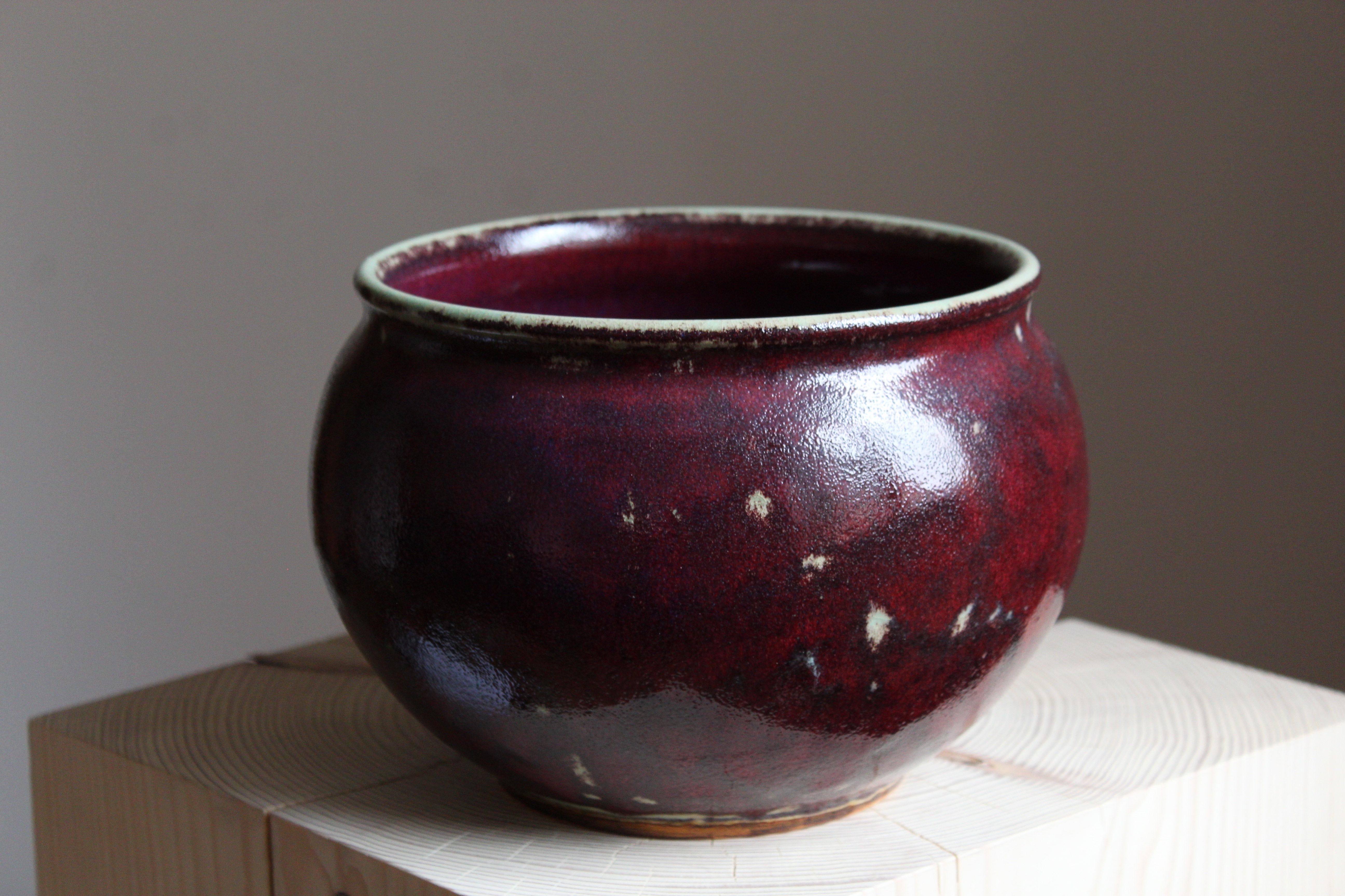 A sizable studio bowl with a red / purple glaze. Made by Ove Thornblad, signed and dated 16/10 -79. Produced by Höganäs Väsby, Sweden.

  