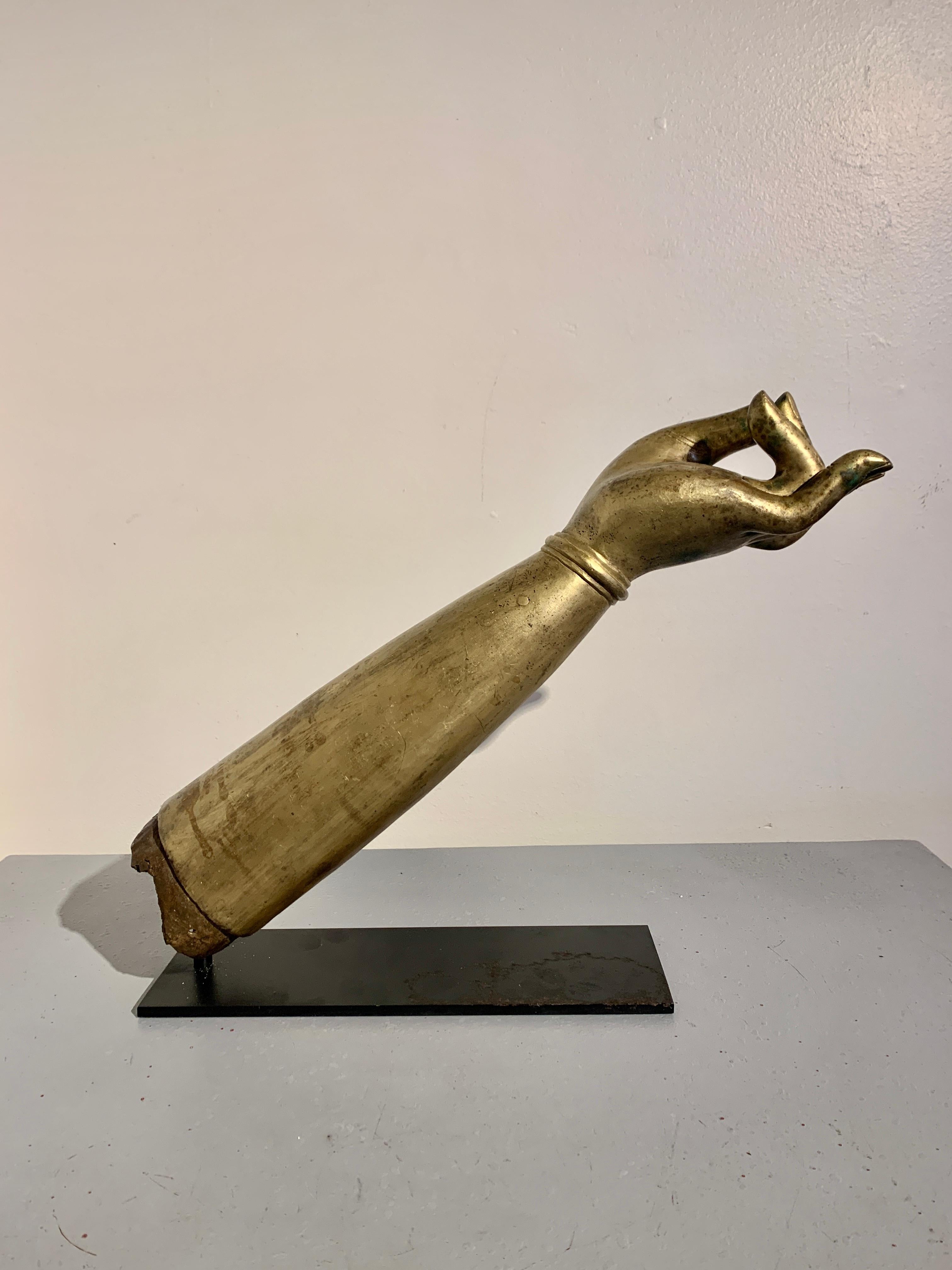 Impressionnante main et bras gauches d'un bodhisattva en bronze coulé et doré, plus grands que nature, fin du XIXe siècle ou plus tôt, Tibet. 

Le bras surdimensionné et la main aux proportions gracieuses. Le bras se rétrécit jusqu'à un poignet