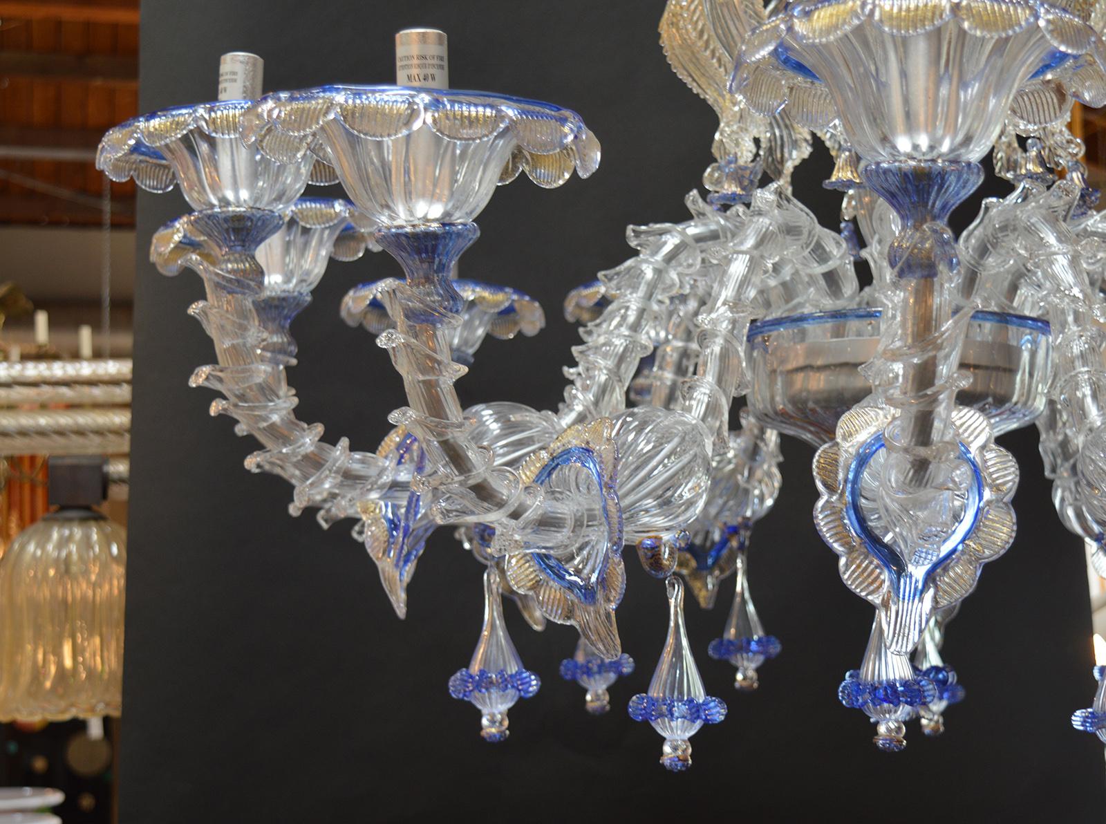 This is a pair of wonderful Murano handmade in Italy chandeliers with a wonderful detail and design in excellent working condition. Blue details with gold flecks.