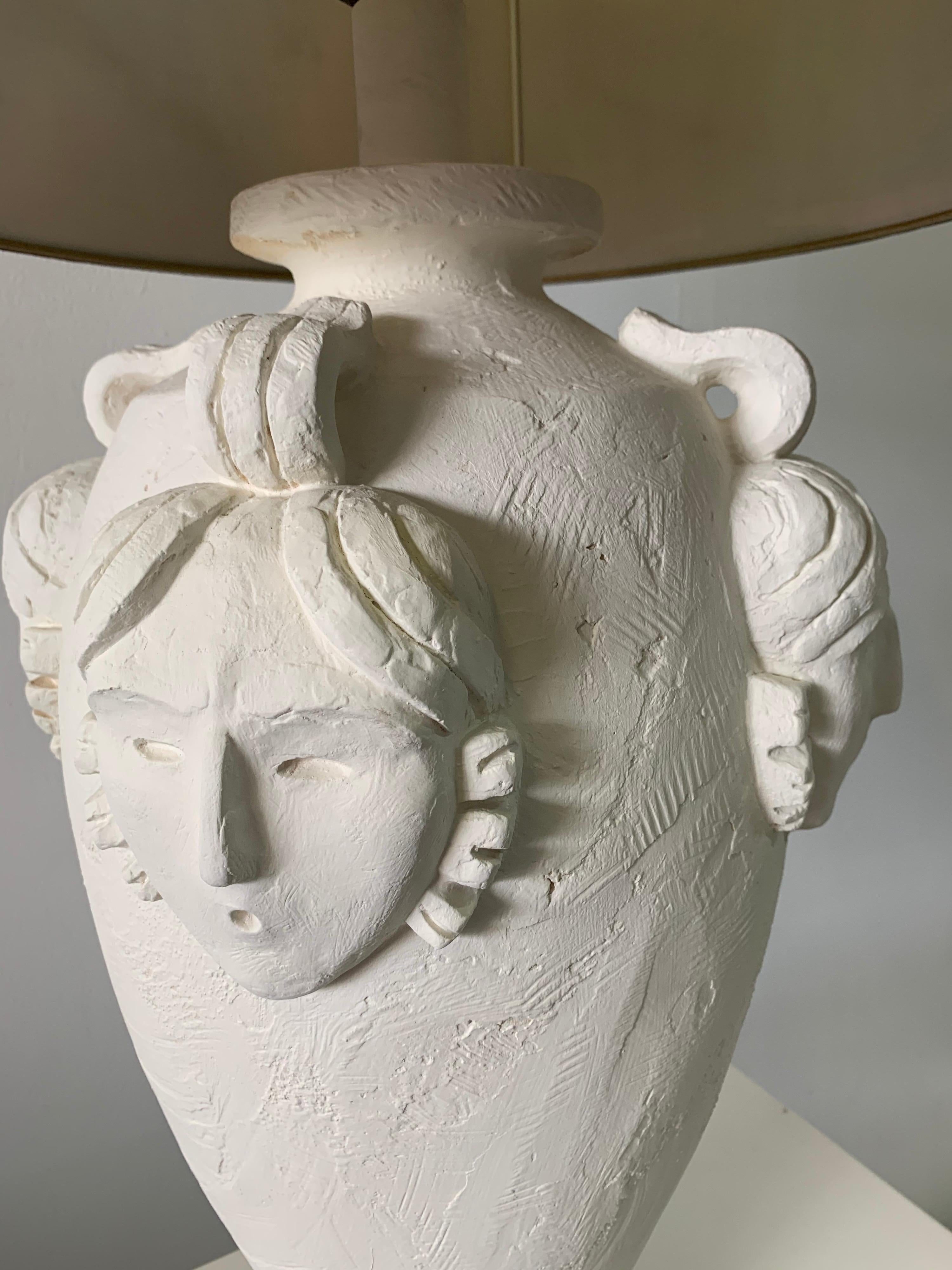 This wonderful coral tone plaster finish table lamp with Art Deco style face accents. Very tall and important.