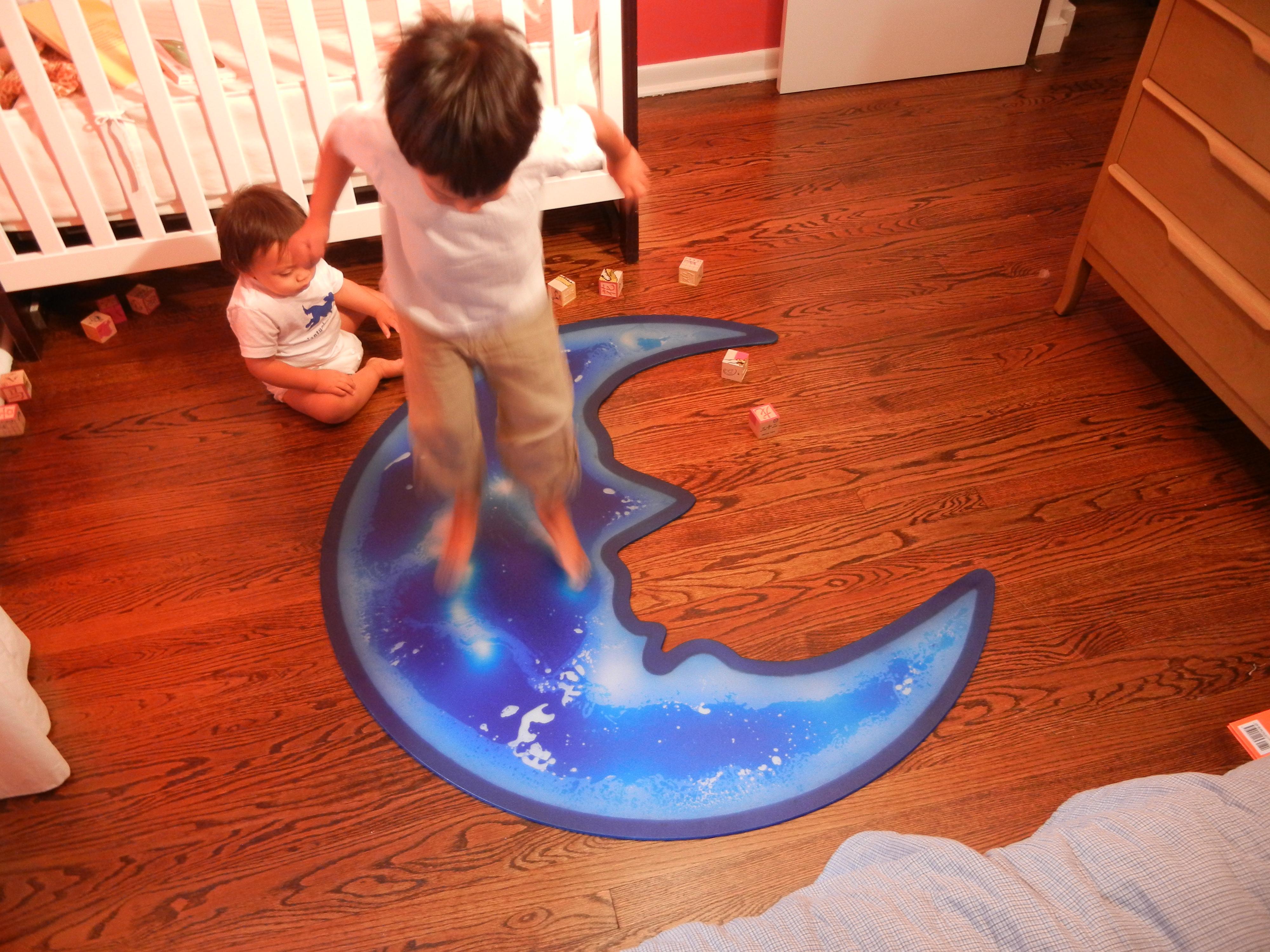 Liquid encased in plastic. 'Over the Moon' children's gel tile by Jody Harrow for Groundplans. Watch the colors move underfoot as you tap on the moon. Available as a 4' semicircle, 5mm thick, custom colors by request. Non-slip mat included.