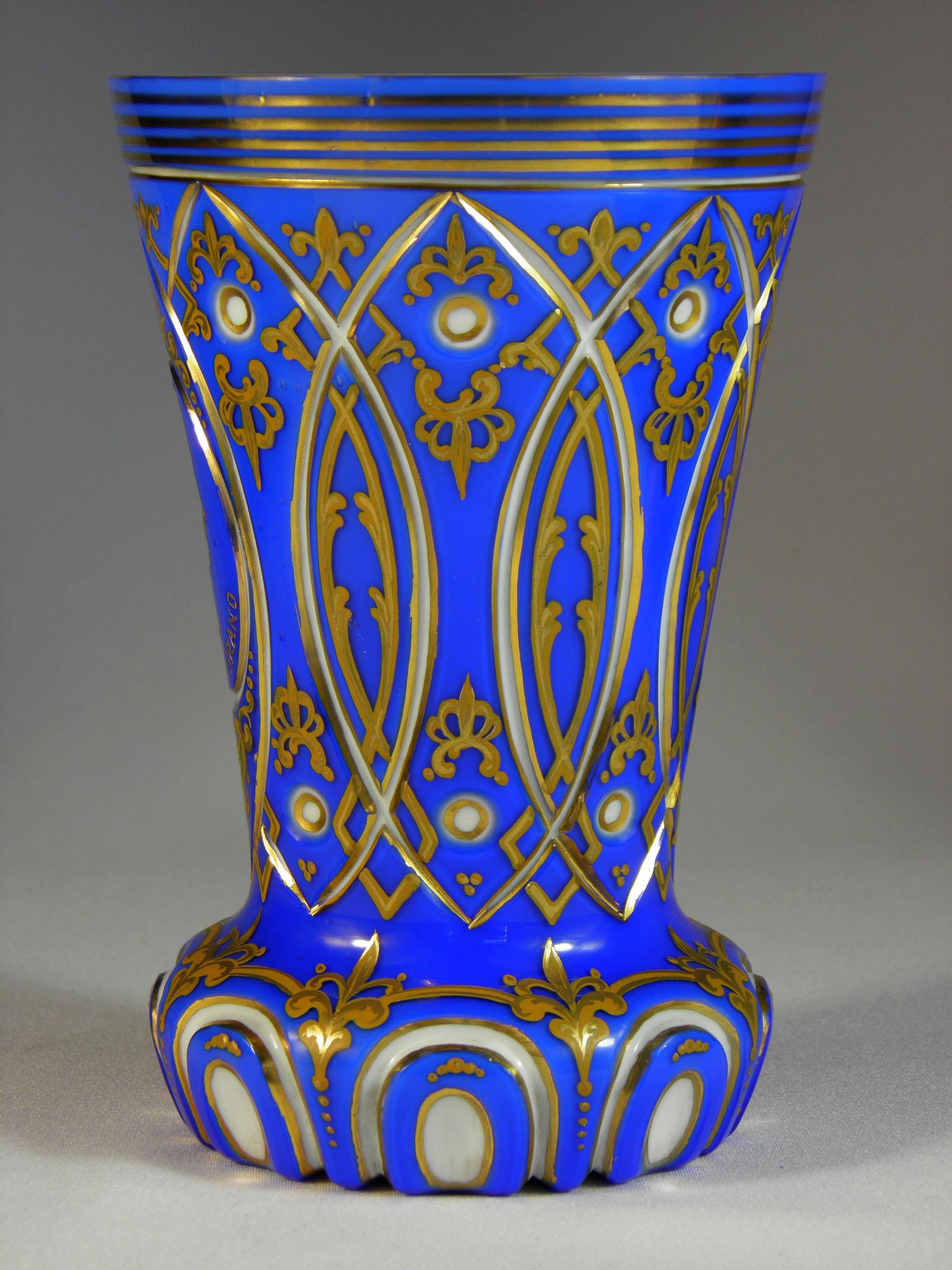 Cup overlaid, cobalt and opal glass, the cup is cut with gilded engraving, painted with ocher colors, drawn in gold, engraved portrait Napoleon Bonaparte Inscription, (NAPOLÉON LE GARD) 19th century. Bohemian Glass.
 