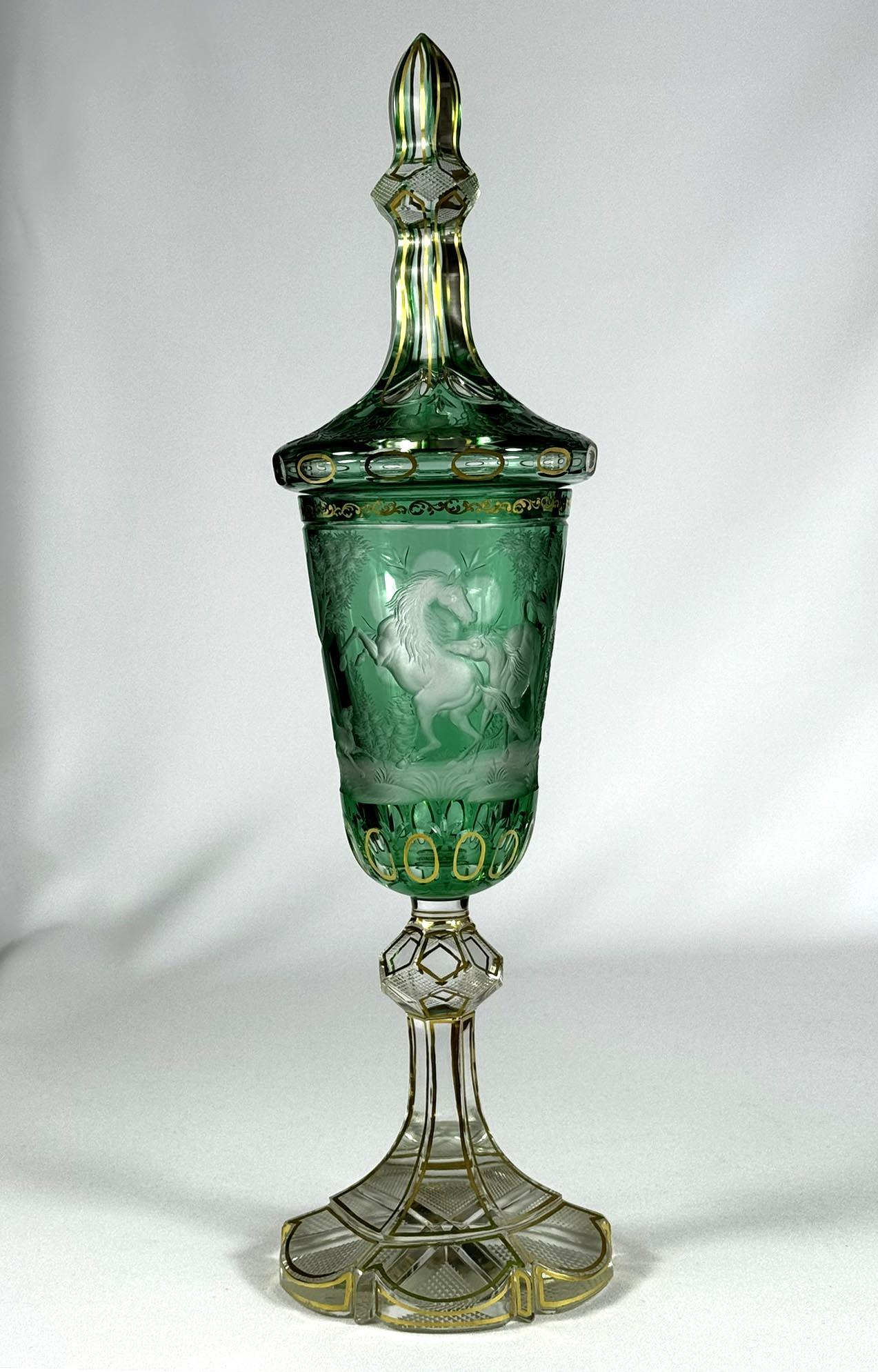 Preciosa copa de cristal con tapa. La copa es de cristal transparente con vidrio verde. Está tallada con un grabado de caballos luchando entre sí, una decoración popular en el siglo XIX. La tapa tiene un grabado de una parra. A continuación, se dora