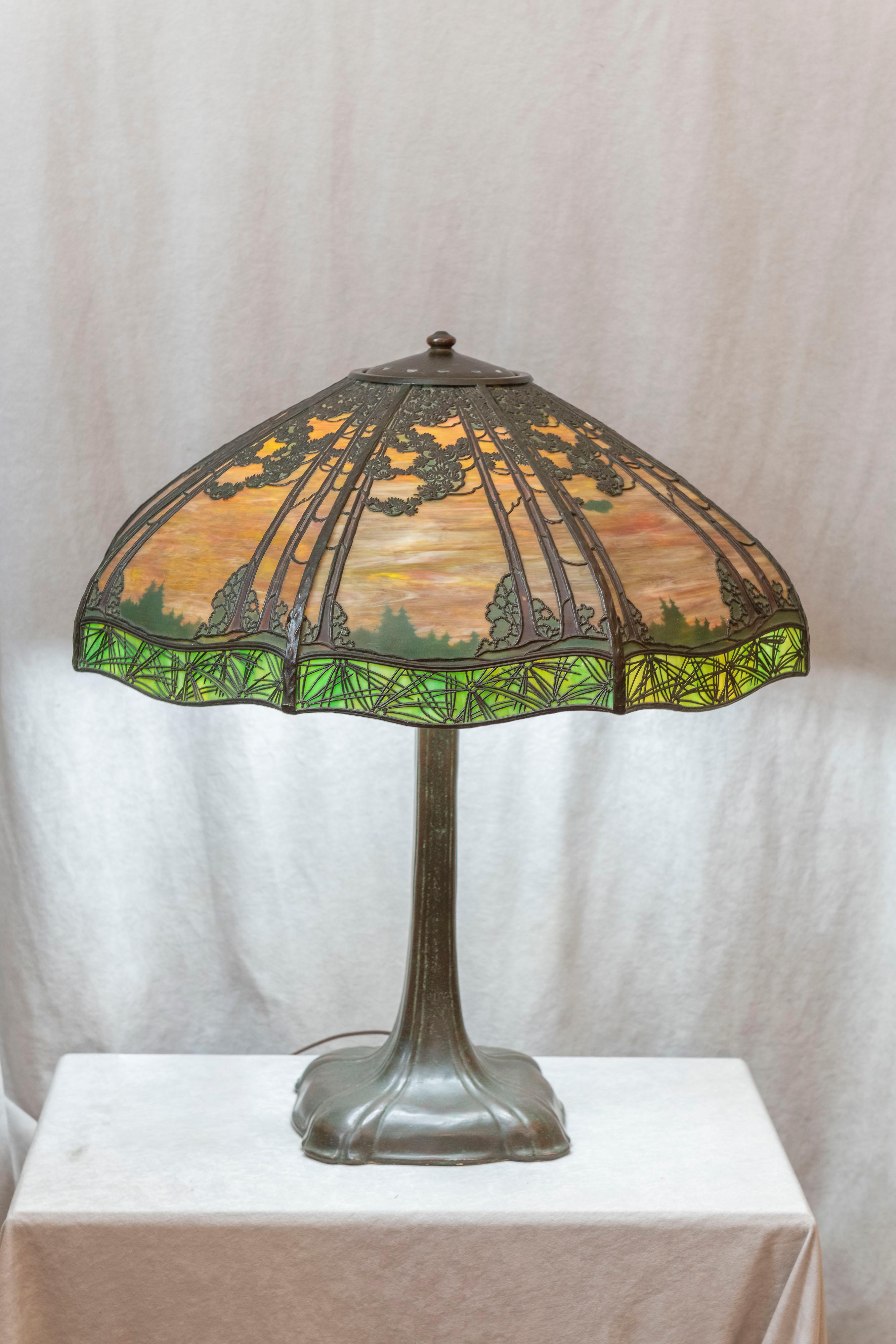 This is a most stunning example of the well known and respected lamp makers of the early 20th century, Handel. These scenic overlays are highly desirable, especially when they lots of beautiful metalwork on each shade panel, and are painted on the