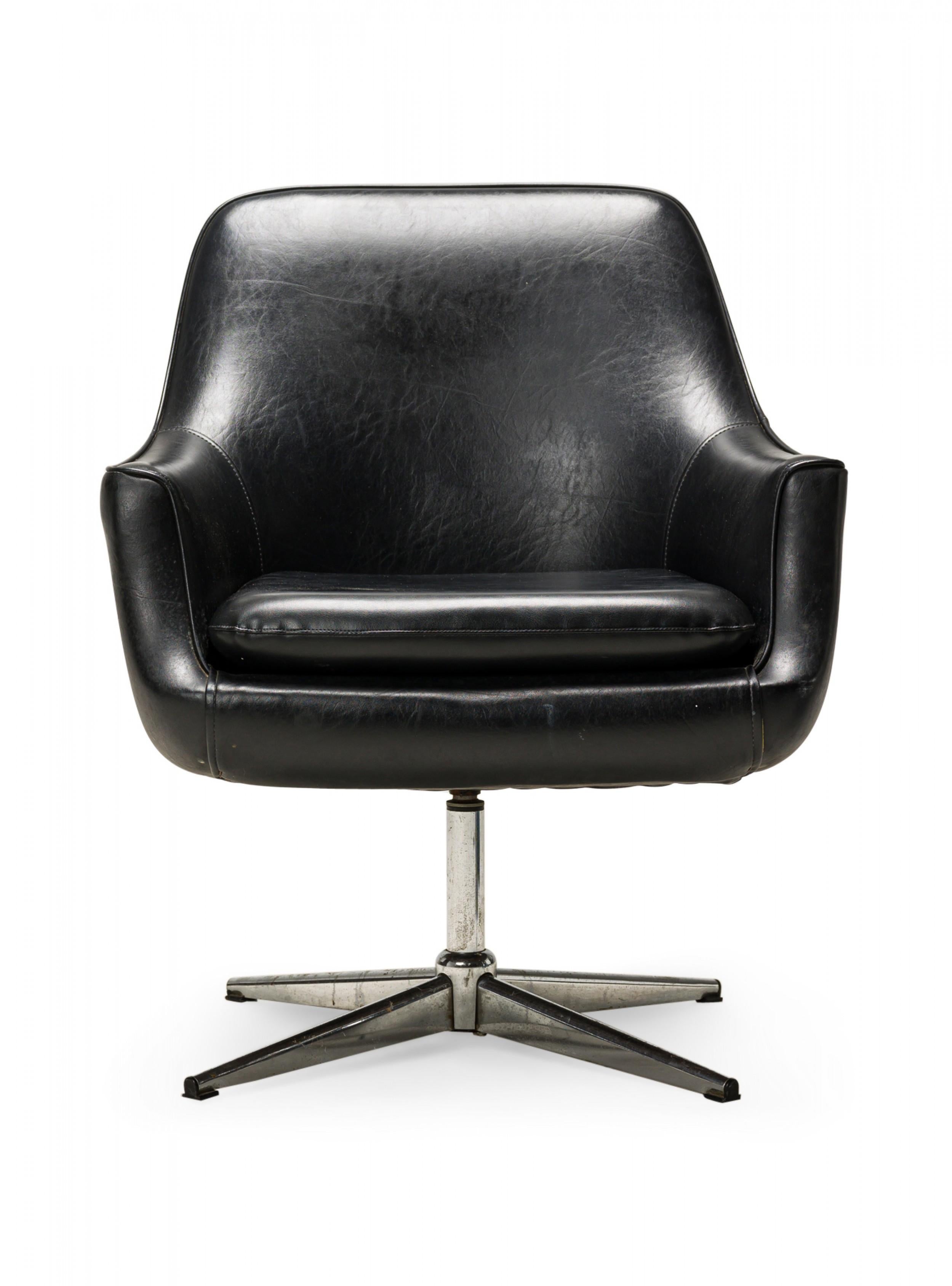 Swedish Mid-Century swivel armchair with black leather upholstery and seat cushion supported on a chrome pedestal base with five legs. (OVERMAN)