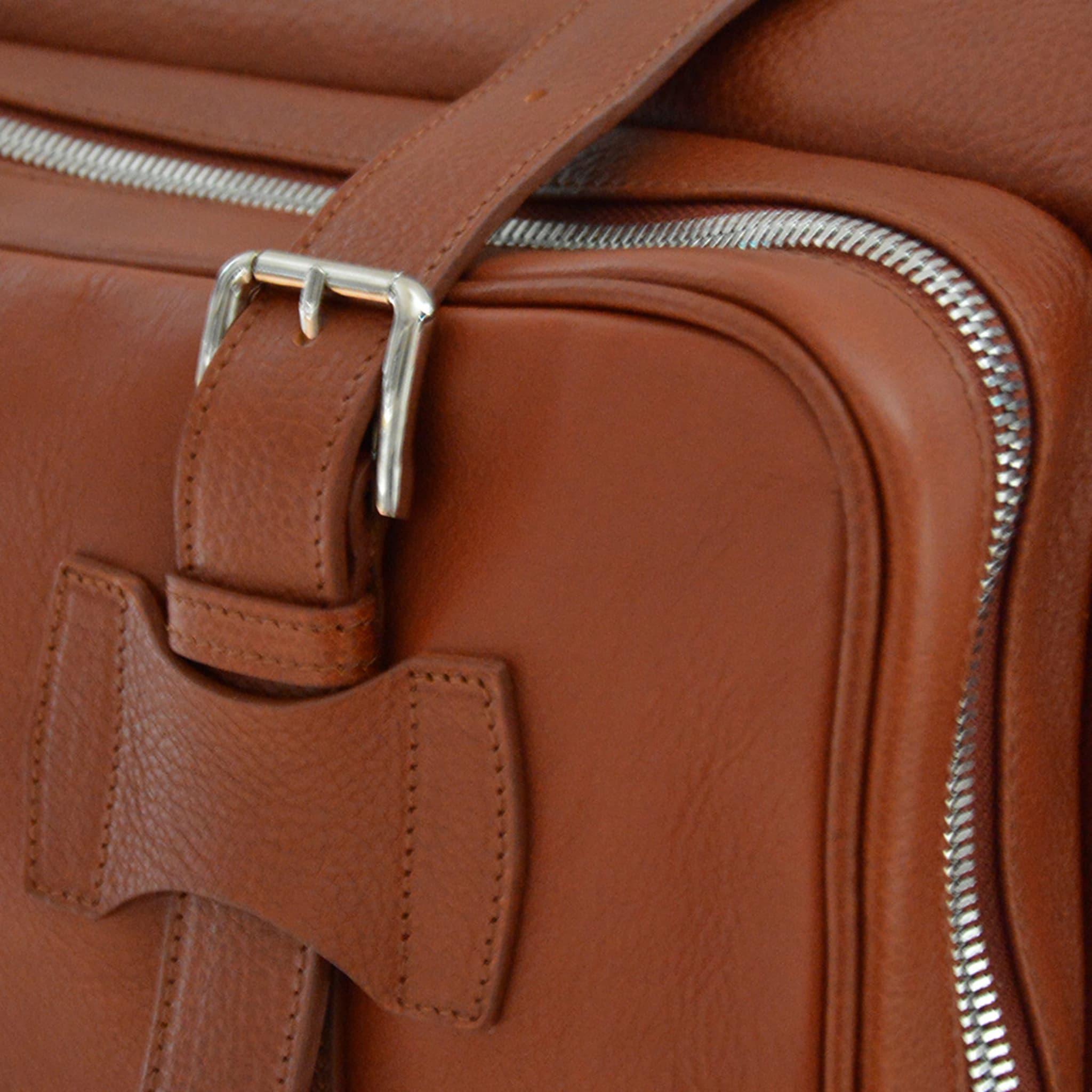 Diese luxuriöse Tasche aus hochwertigem, pflanzlich gegerbtem Leder enthält Innentaschen, eine Außentasche auf der Vorderseite und zwei Seitentaschen. Ein optionaler und verstellbarer Schulterriemen verleiht dieser eleganten braunen Overnight Bag